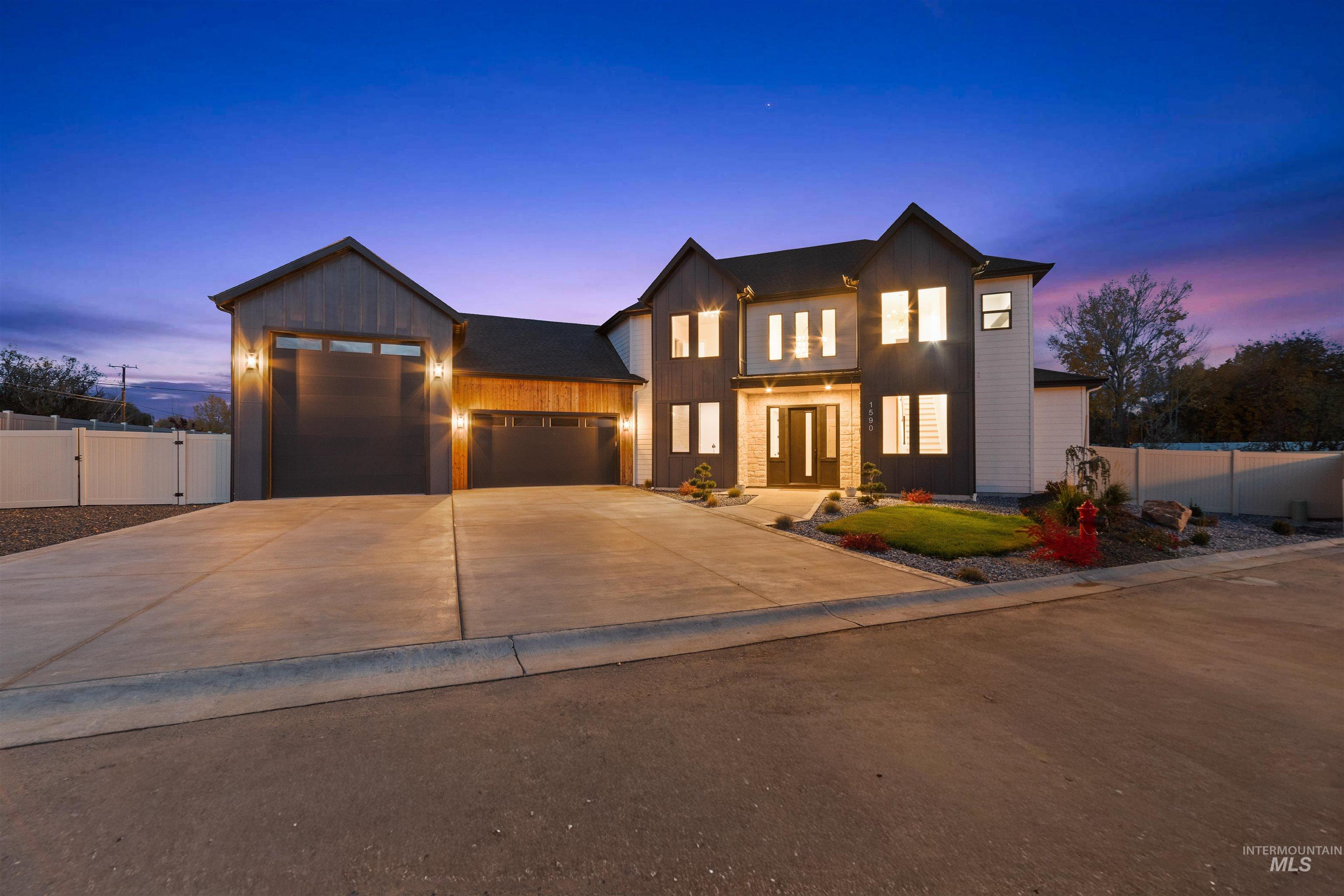 View of front of property featuring board and batten siding, a garage, and driveway
