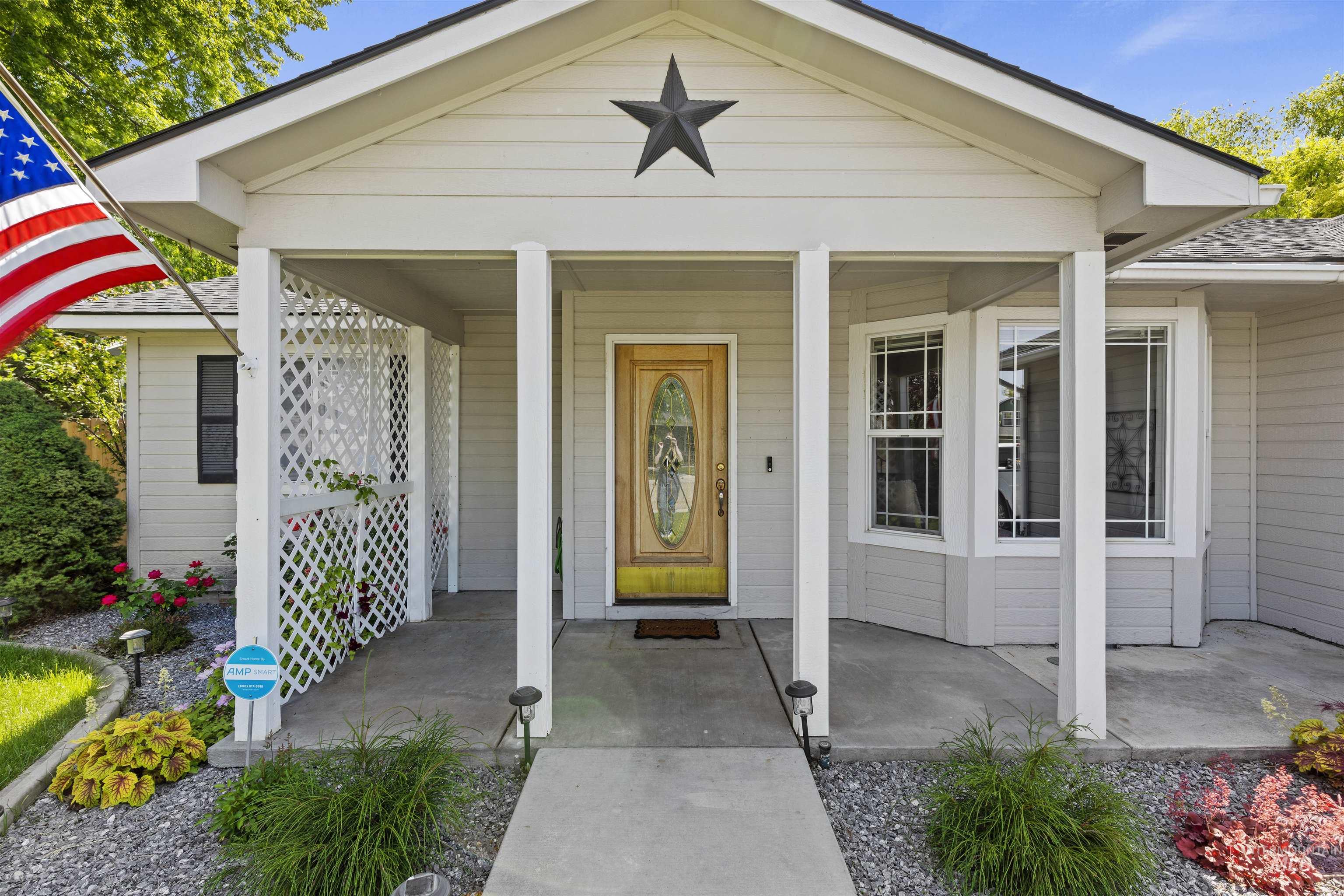 View of exterior entry featuring a porch and a shingled roof