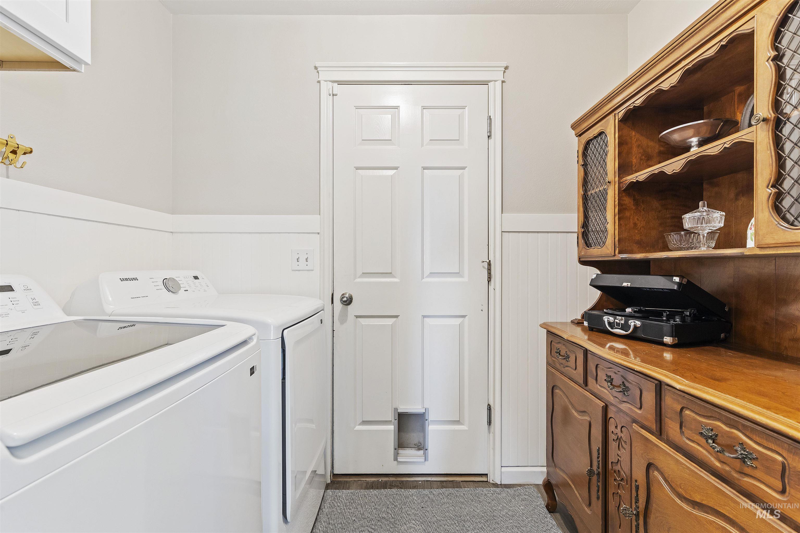 Washroom with wainscoting and separate washer and dryer