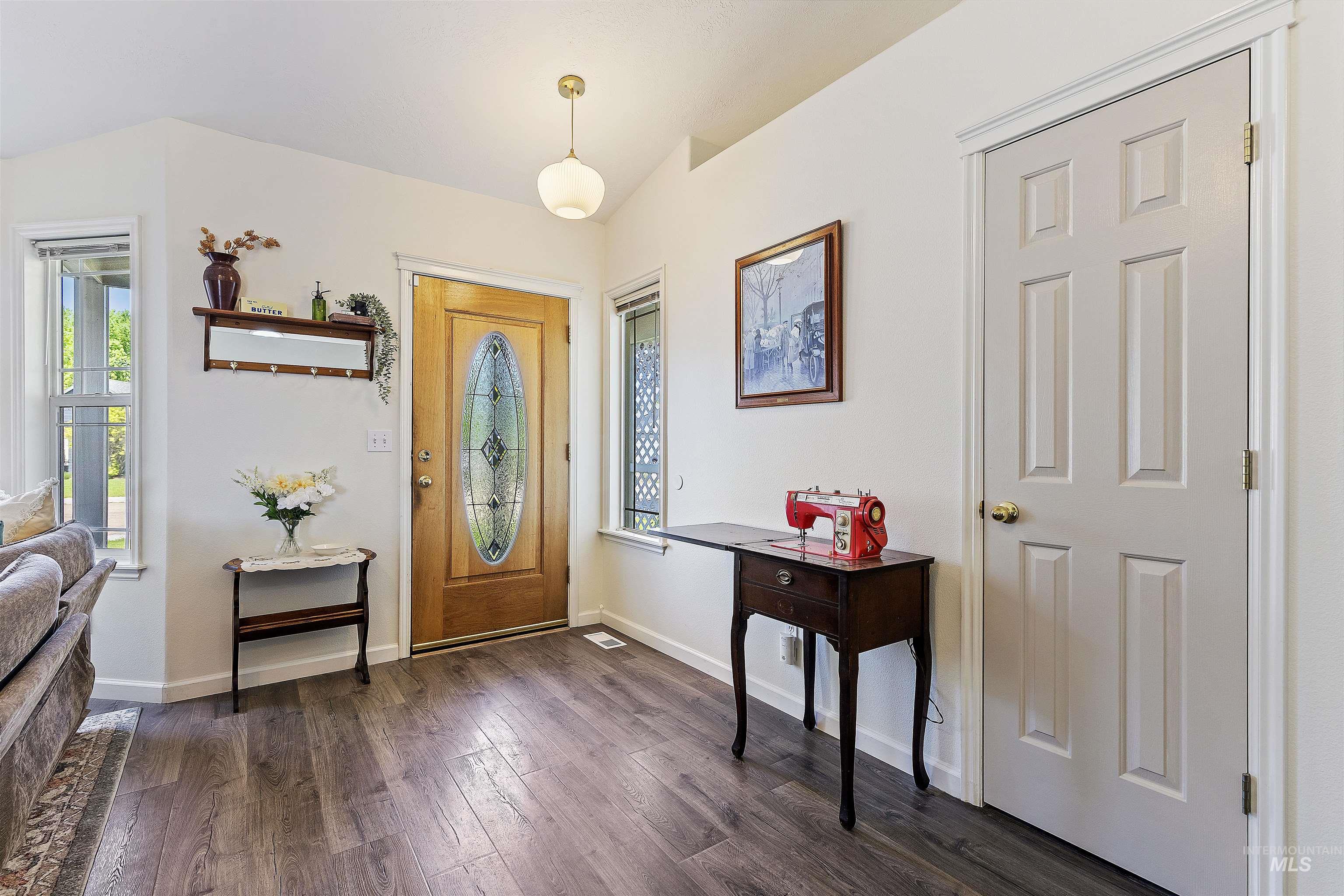 Foyer featuring dark wood-type flooring and baseboards