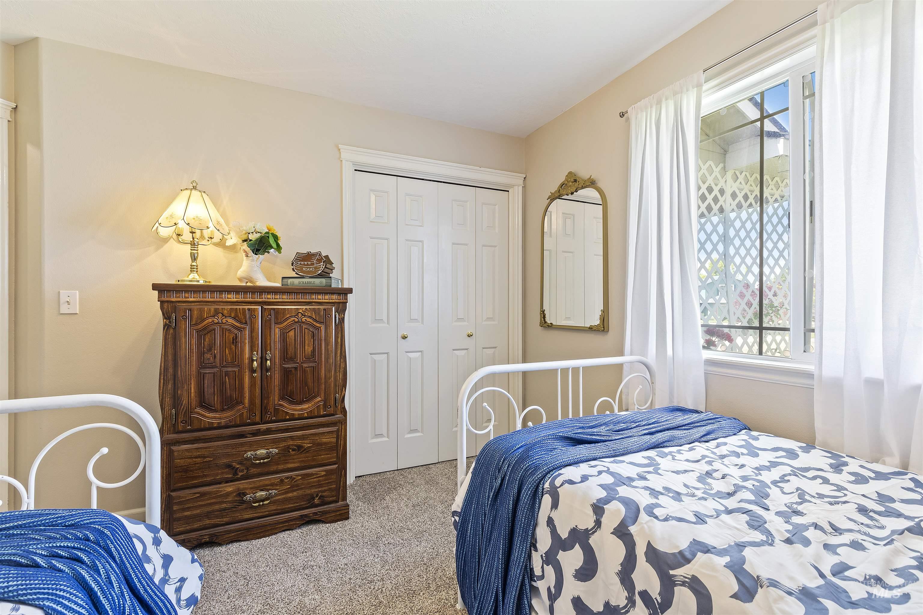 Bedroom with carpet, multiple windows, and a closet