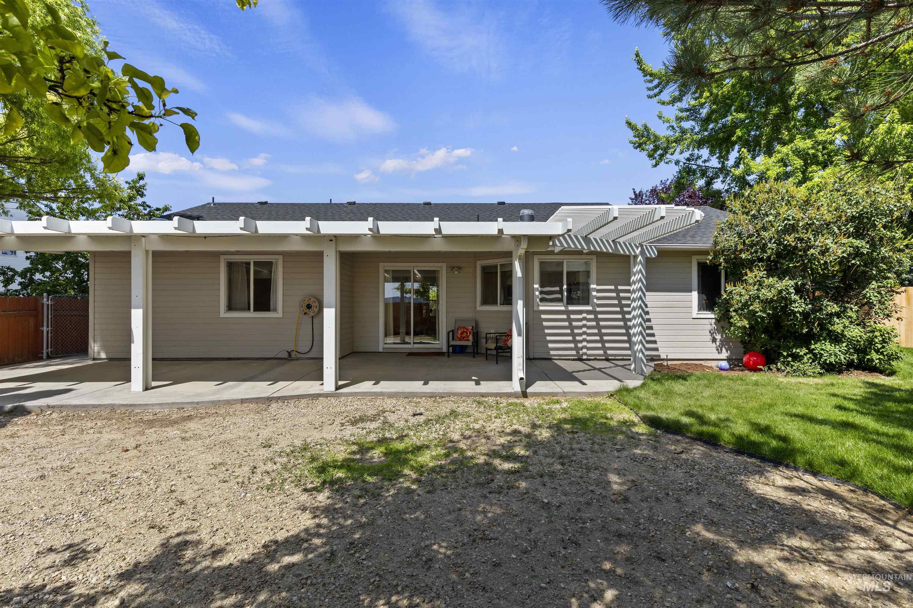 Rear view of house featuring a patio area and roof with shingles