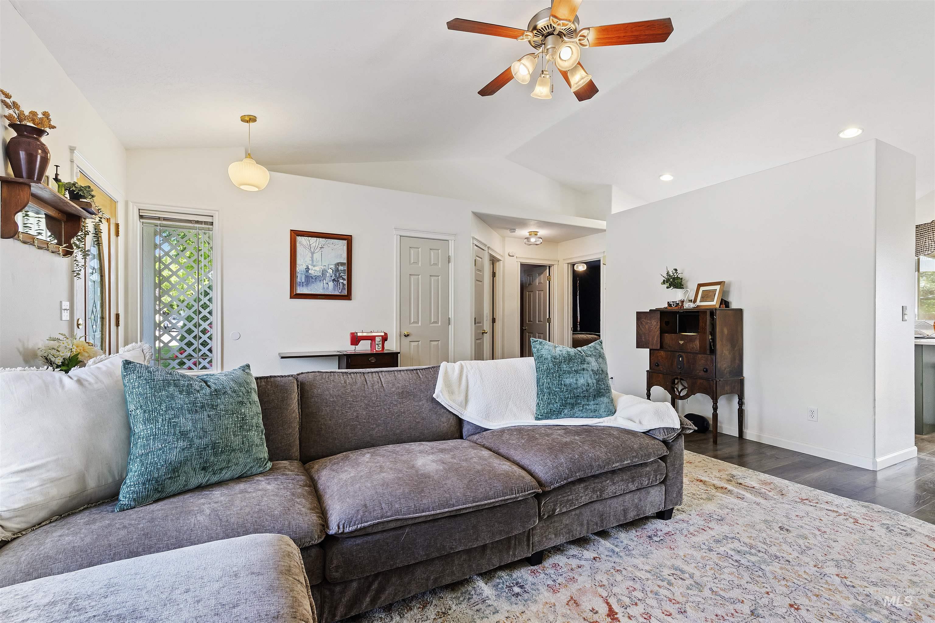 Living area featuring lofted ceiling, wood finished floors, ceiling fan, and recessed lighting