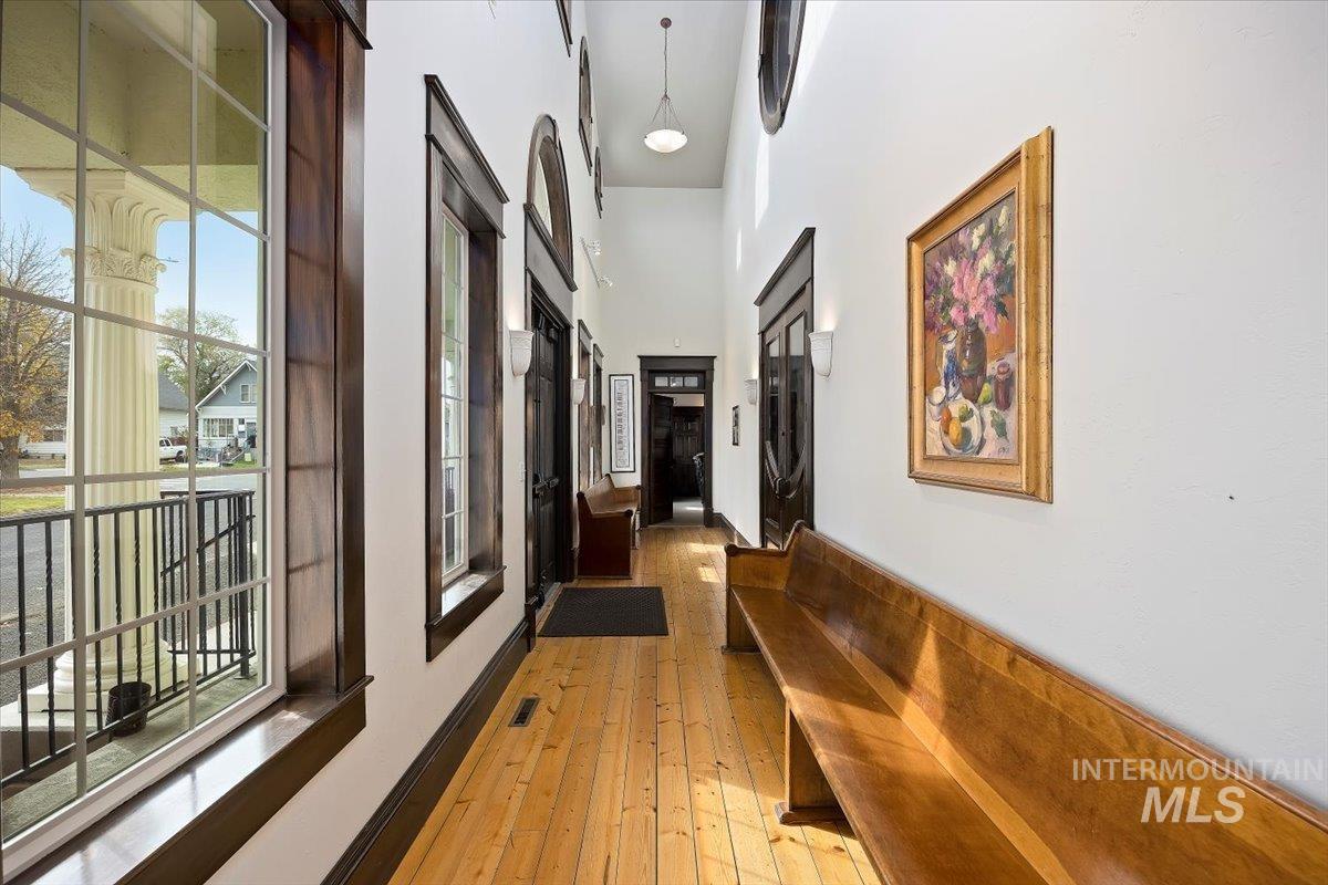 Hall with light wood-style flooring and a high ceiling