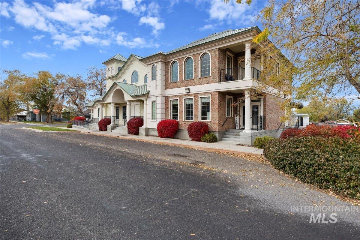 View of front of home featuring brick siding and a balcony