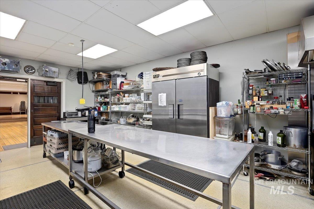 Kitchen with a drop ceiling and high end fridge