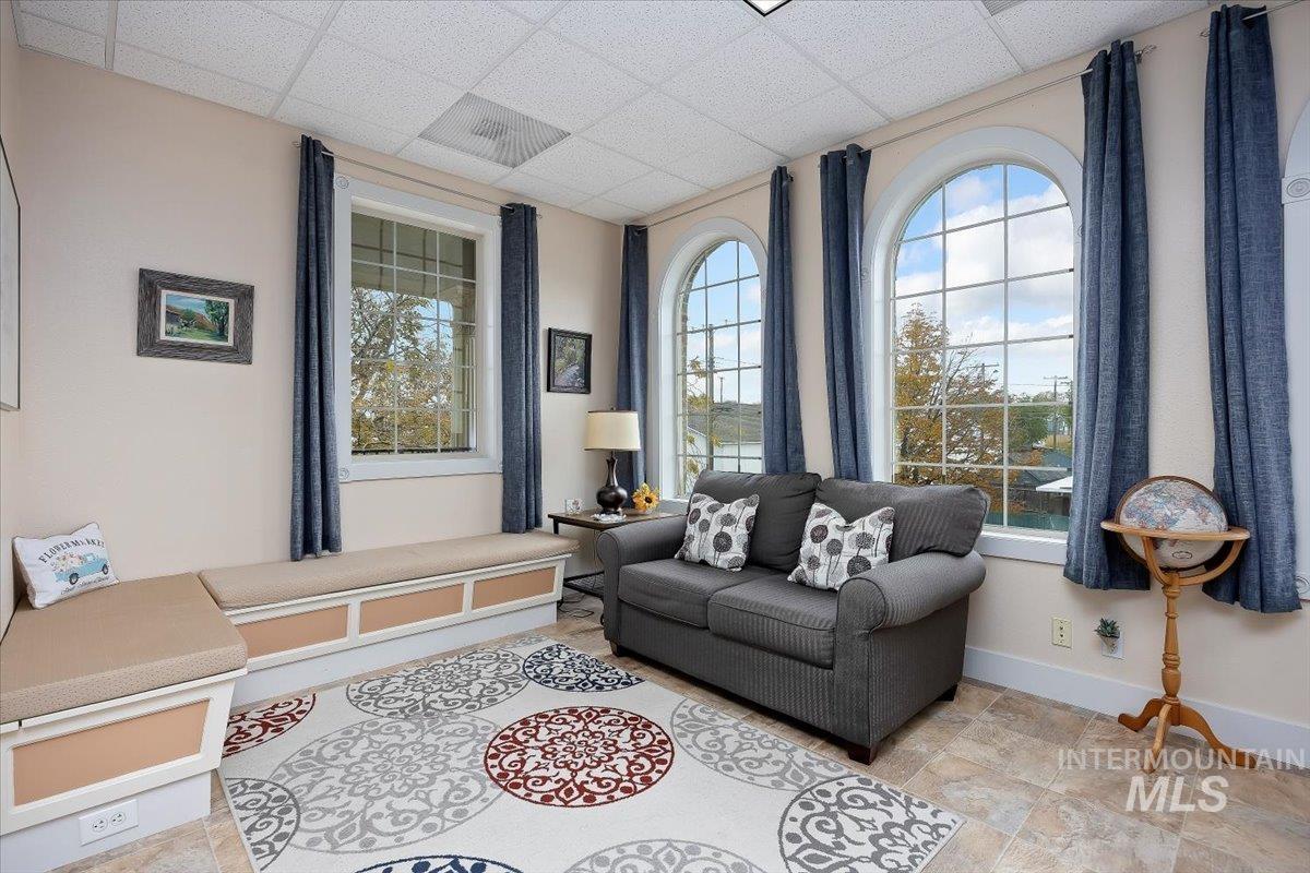 Living room with healthy amount of natural light and a drop ceiling