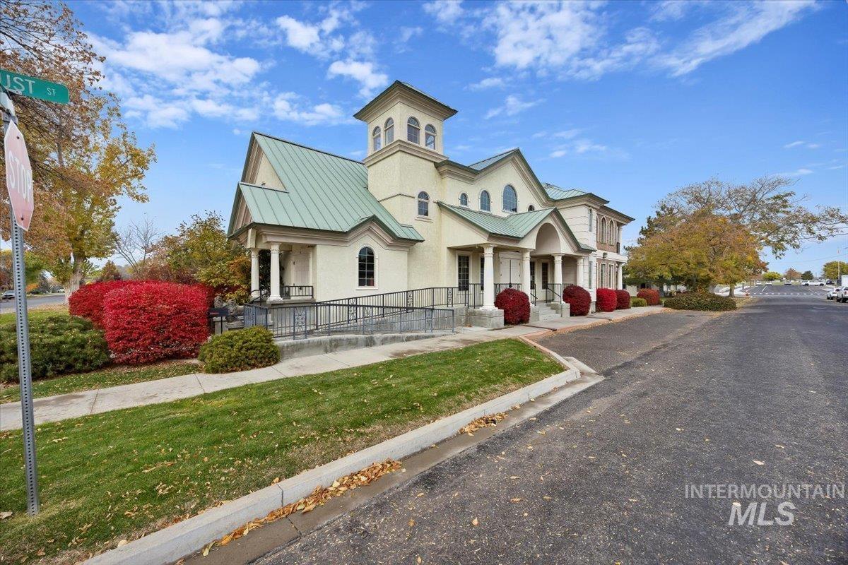 View of front of home featuring a metal roof, a standing seam roof, stucco siding, and a front yard
