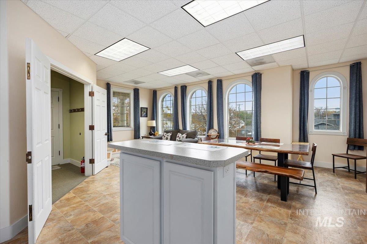 Kitchen featuring a paneled ceiling, a kitchen island, and light countertops
