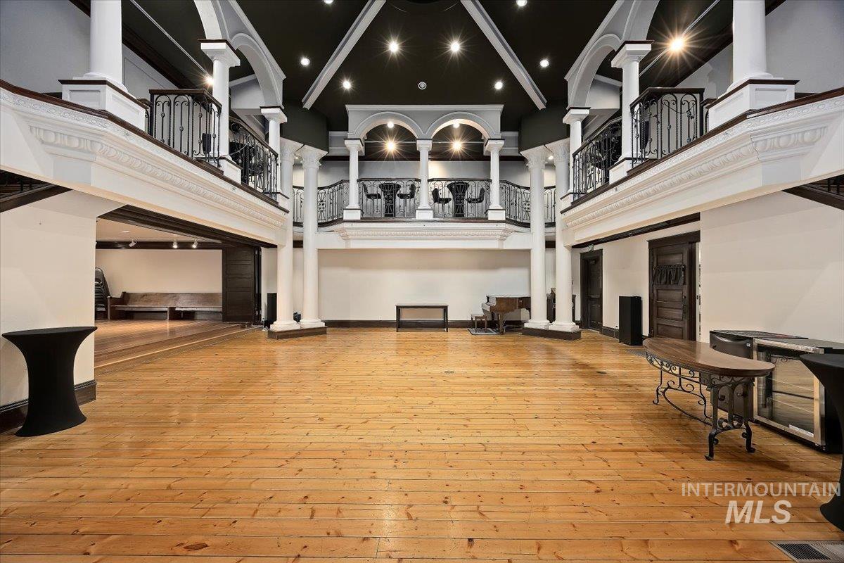 Interior space featuring a high ceiling, decorative columns, and beam ceiling
