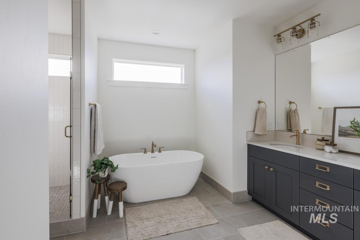Bathroom featuring a soaking tub, a shower stall, vanity, and light tile patterned floors