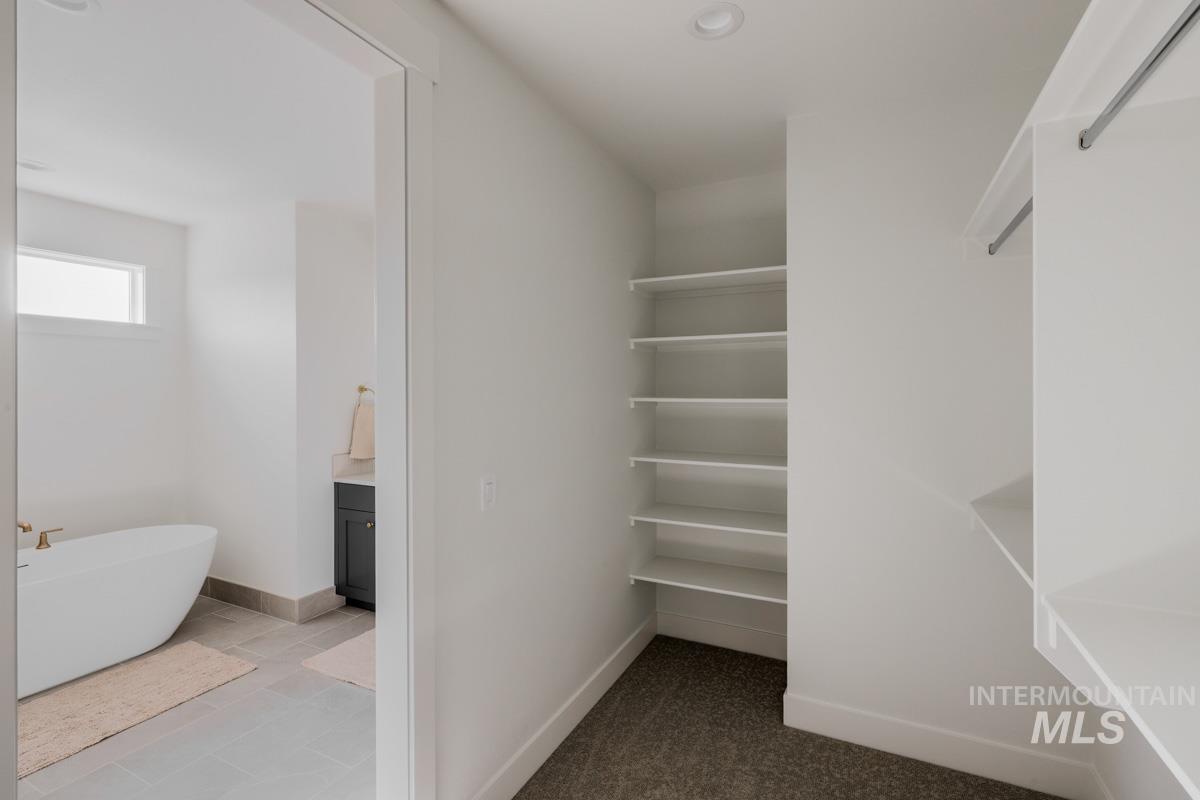 Walk in closet featuring dark tile patterned floors
