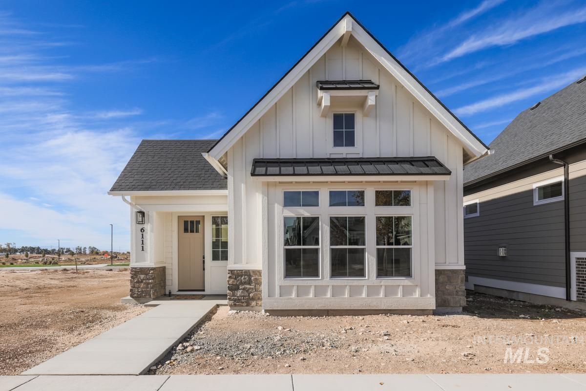 Modern farmhouse style home featuring board and batten siding, a standing seam roof, a metal roof, stone siding, and a shingled roof