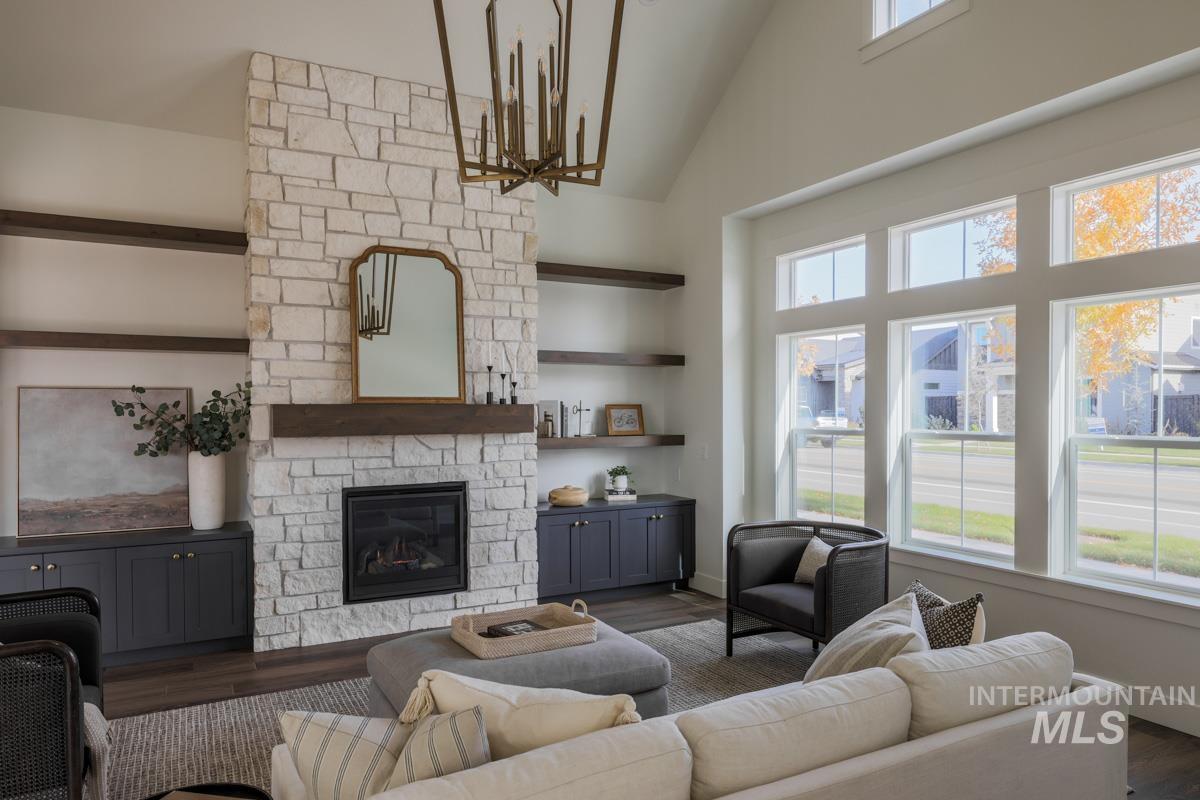 Living area featuring a fireplace, dark wood-style flooring, and high vaulted ceiling