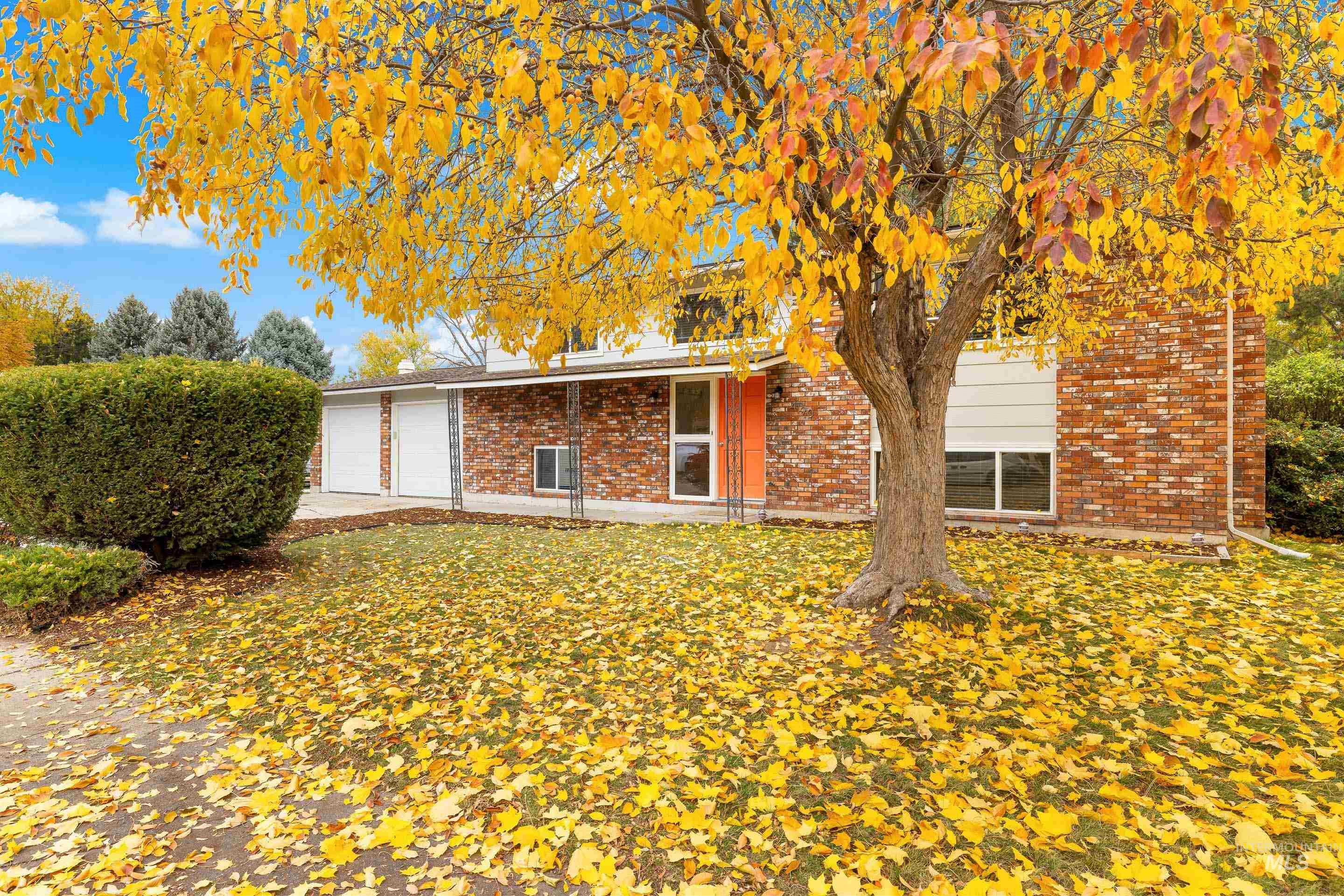 View of front facade featuring brick siding, concrete driveway, and an attached garage