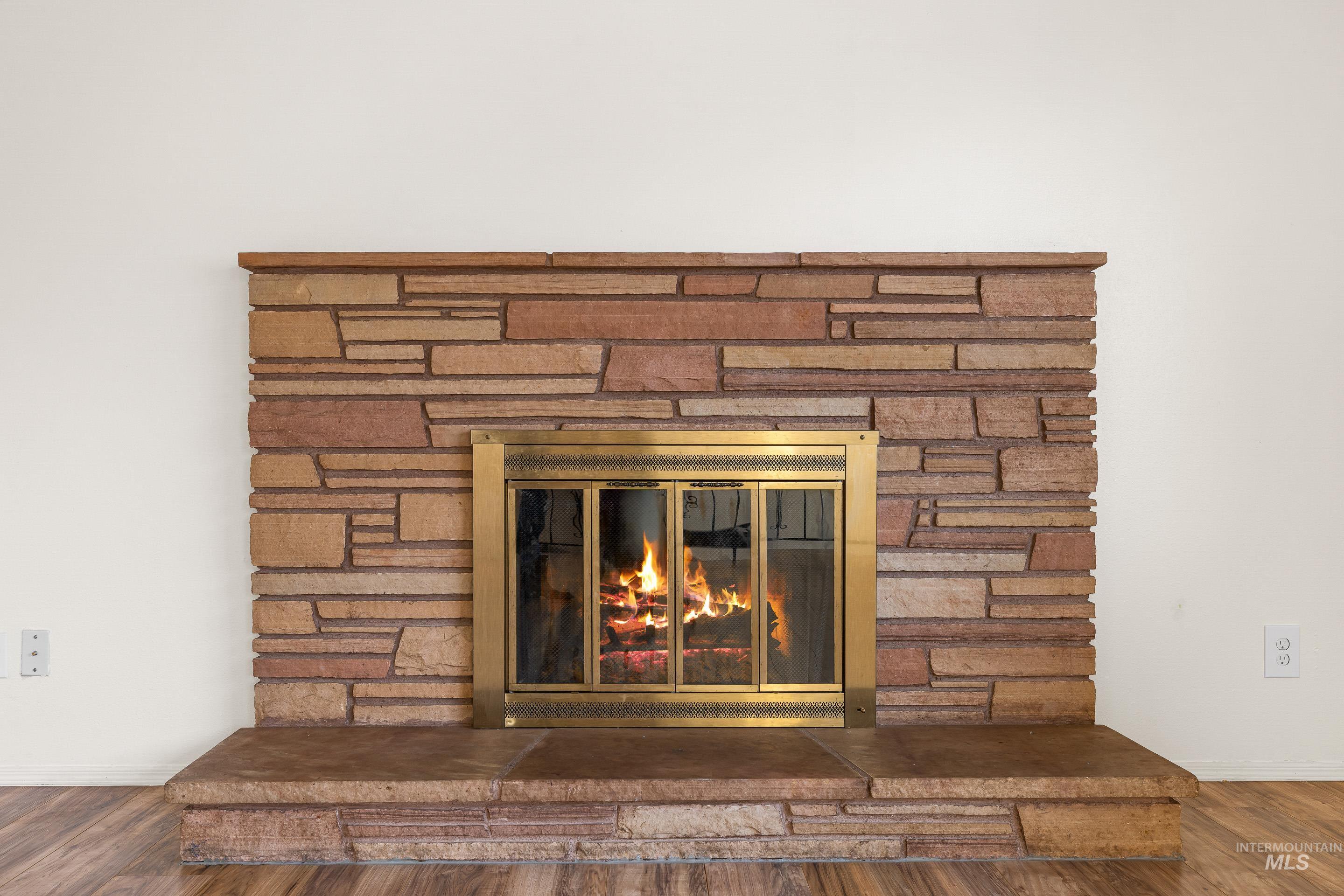 Detailed view of wood finished floors and a fireplace