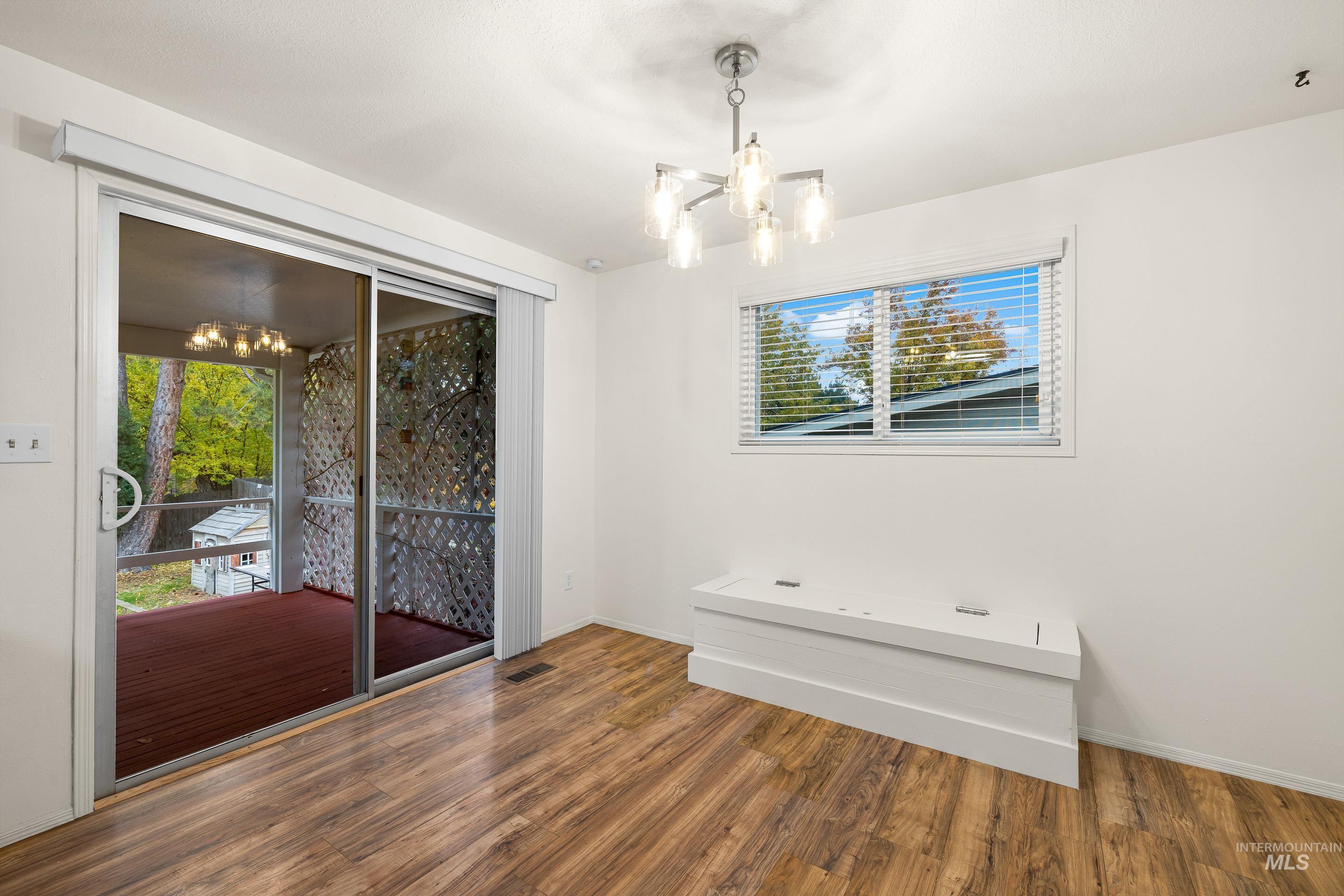 Spare room featuring a chandelier and wood finished floors