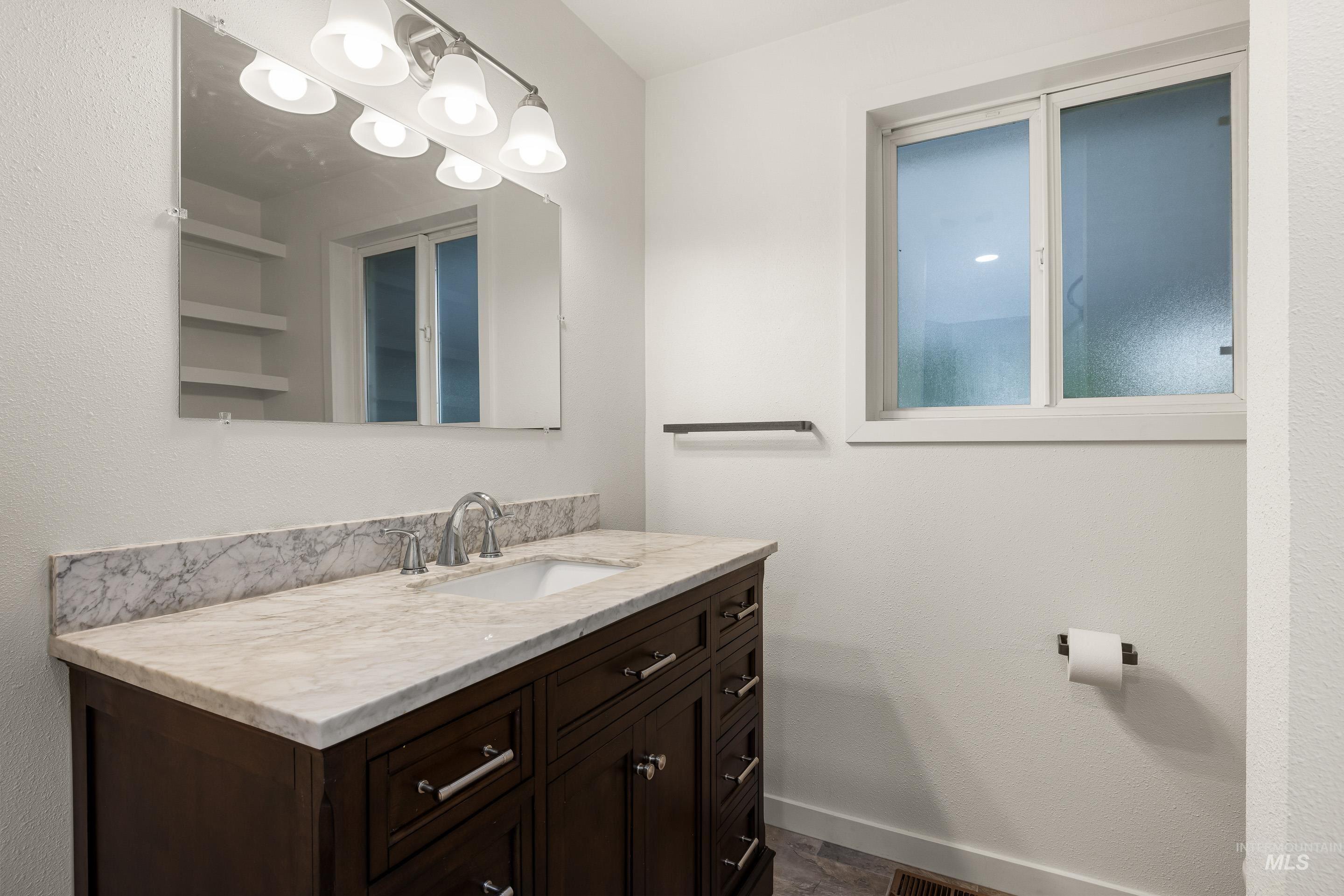 Bathroom featuring vanity and a textured wall