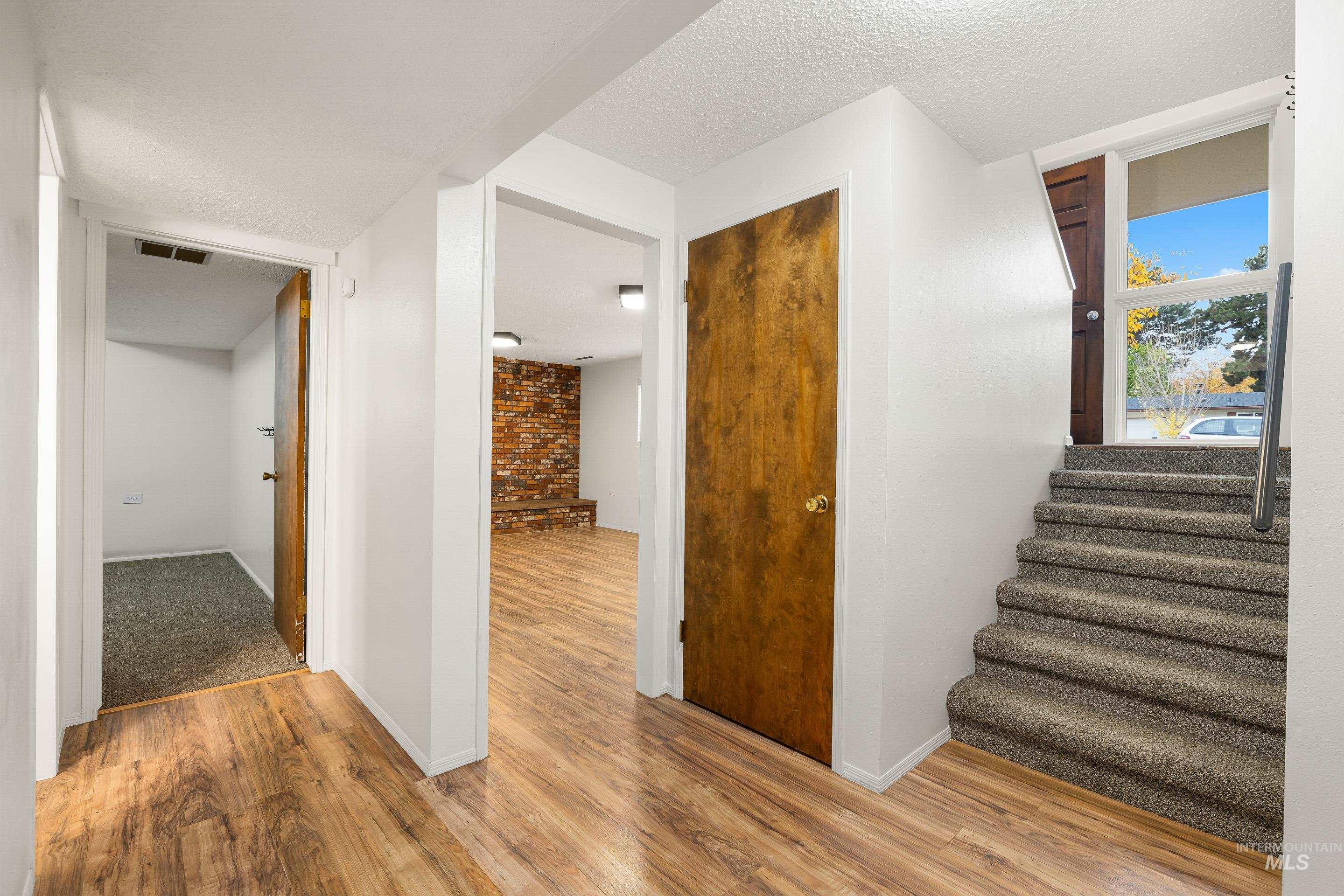 Stairs featuring wood finished floors and a textured ceiling