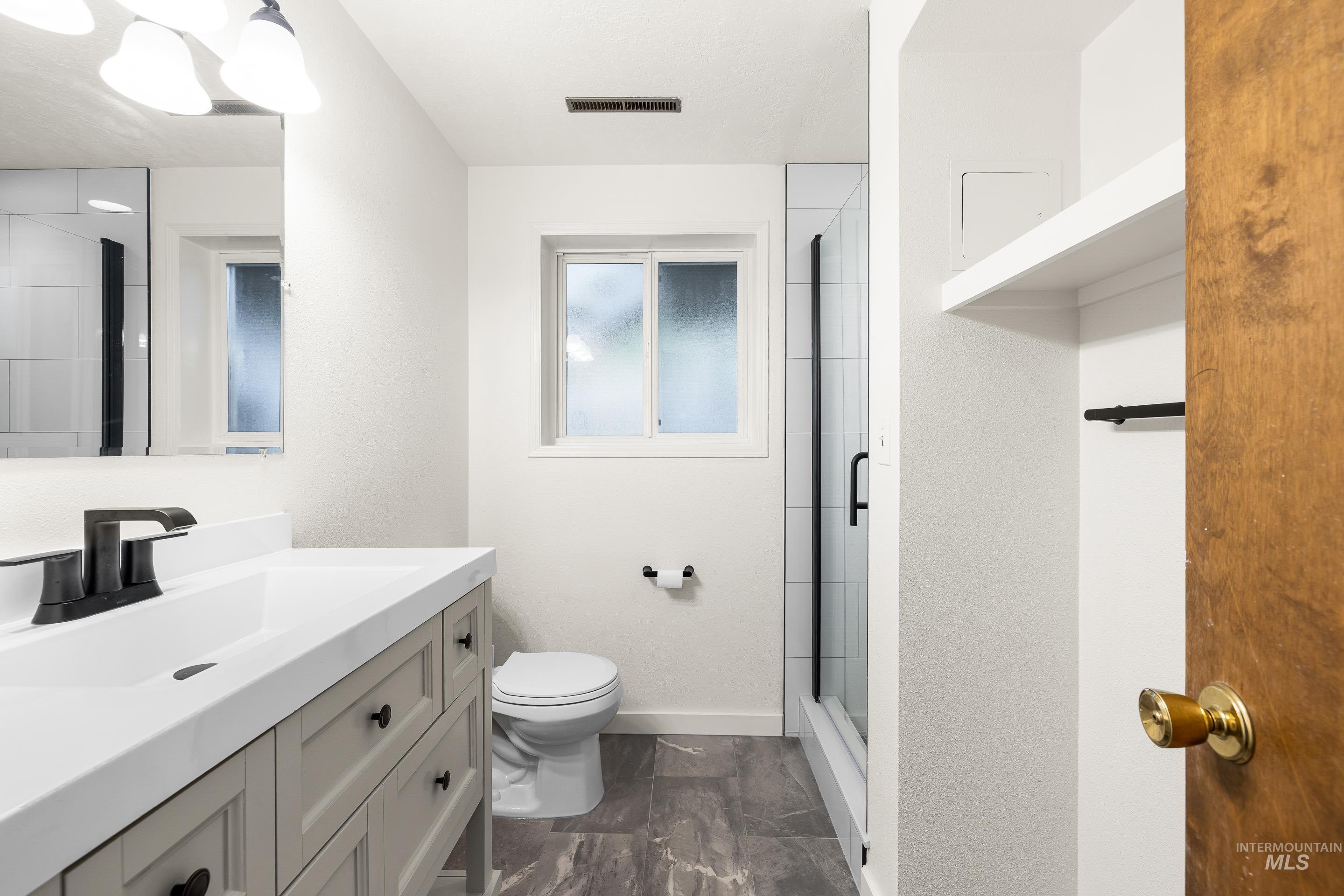 Full bathroom featuring vanity and a shower stall