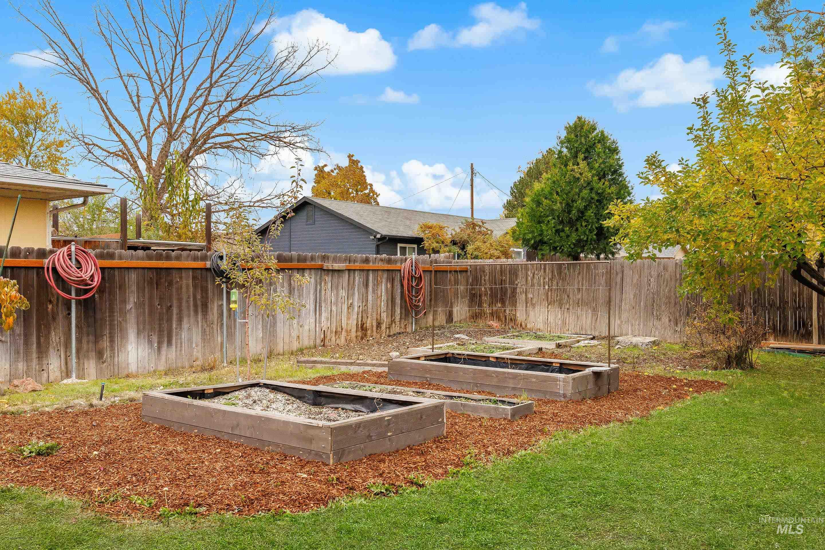 Fenced backyard featuring a vegetable garden