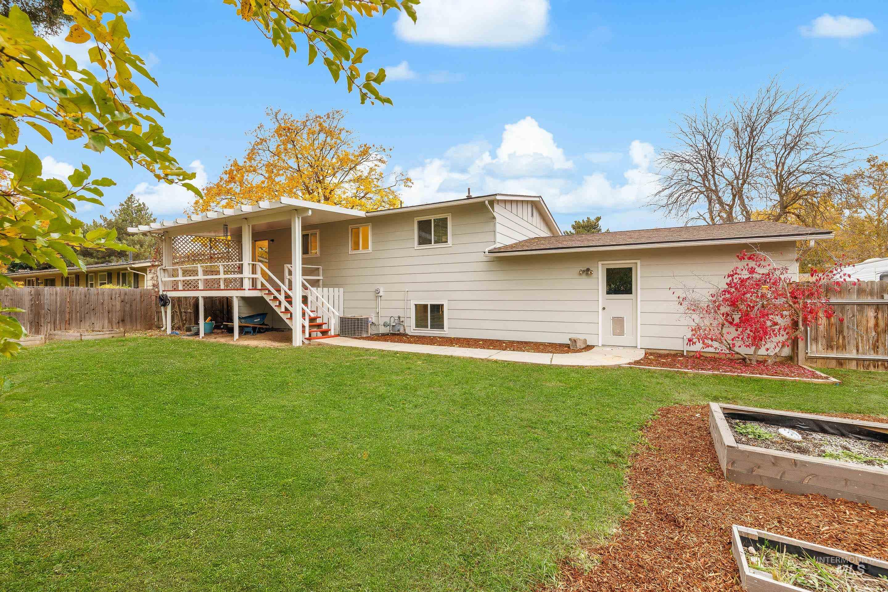 Back of property with a fenced backyard, stairs, and a garden