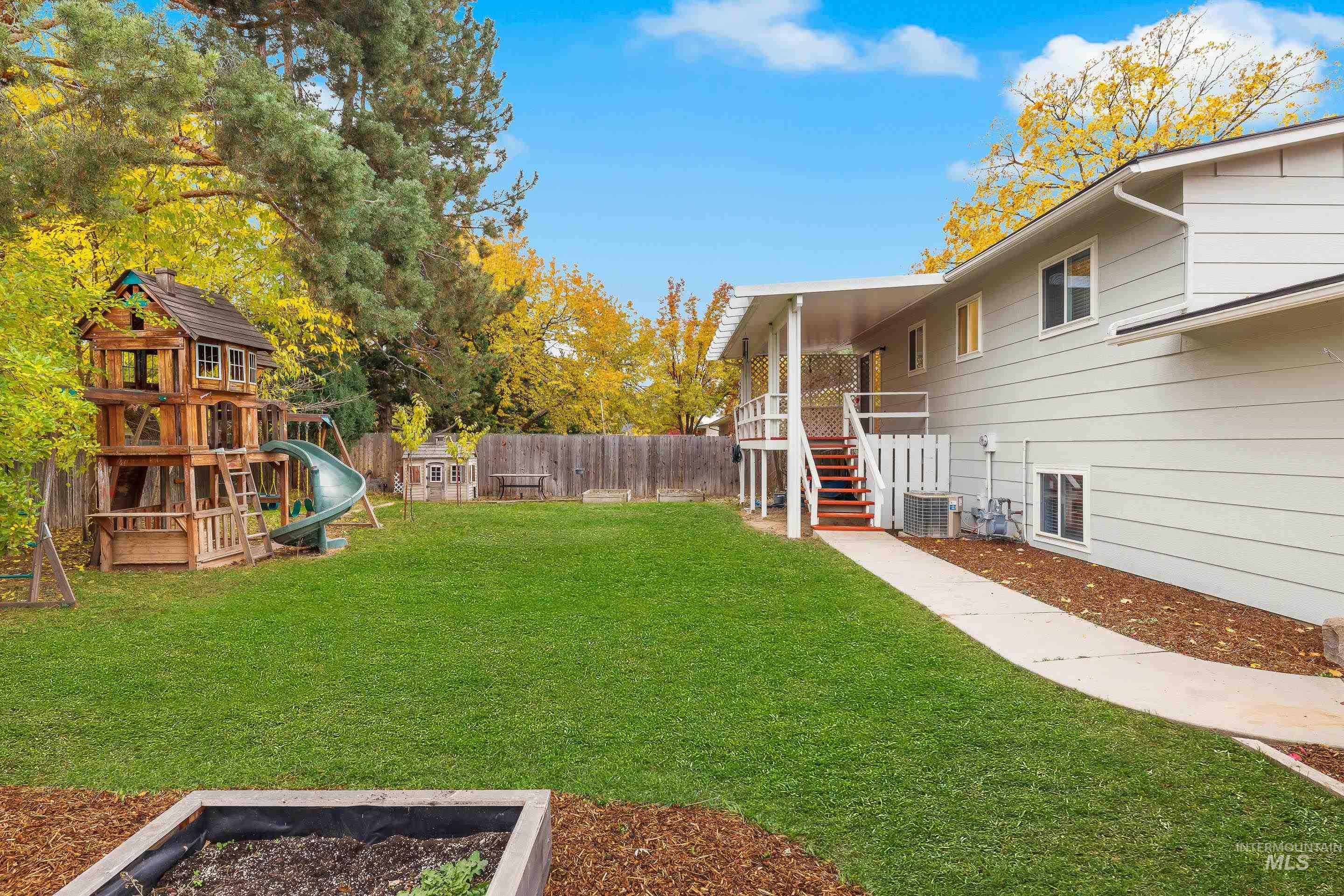 Fenced backyard with a playground and stairway