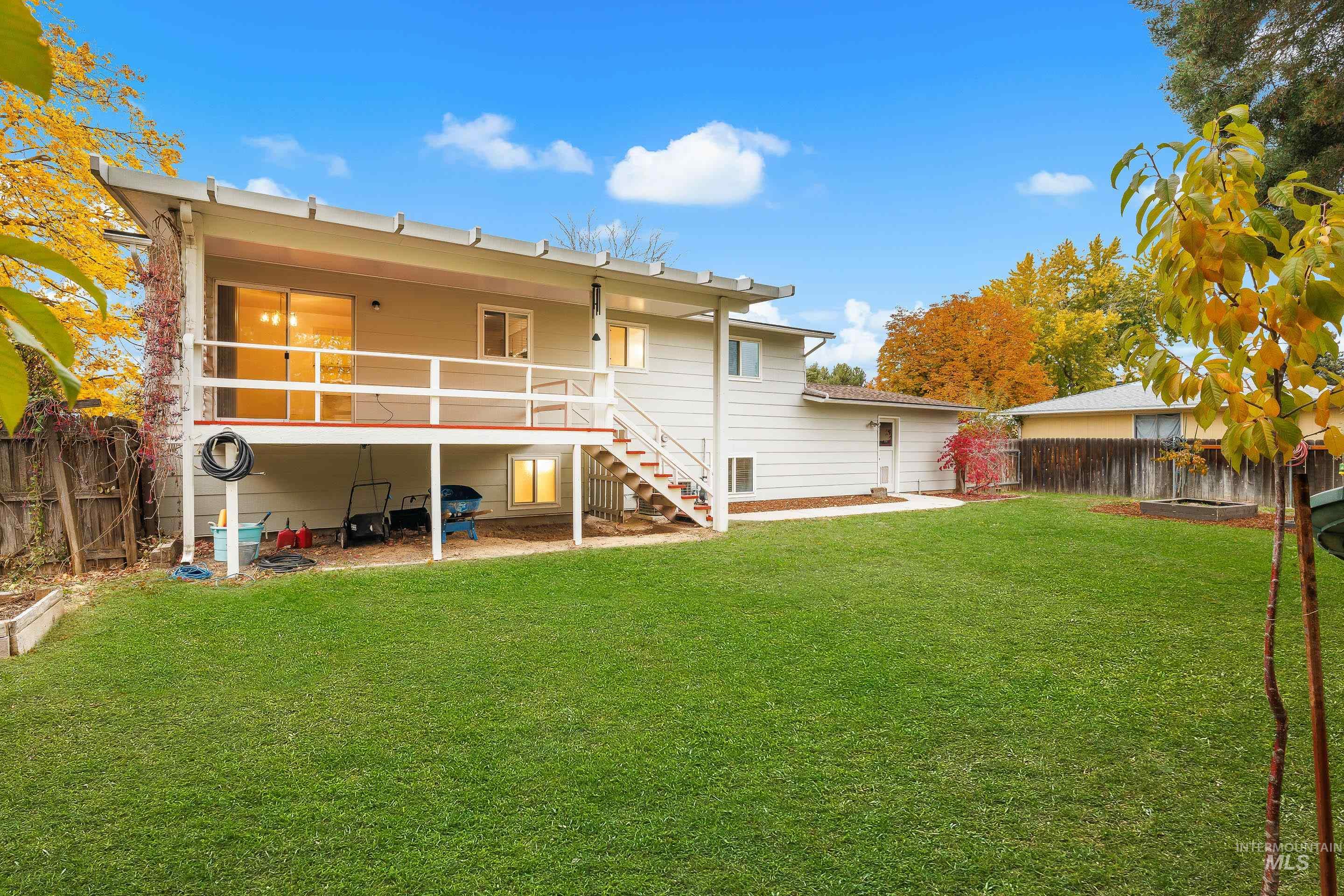 Rear view of house with stairway, a fenced backyard, and a patio area