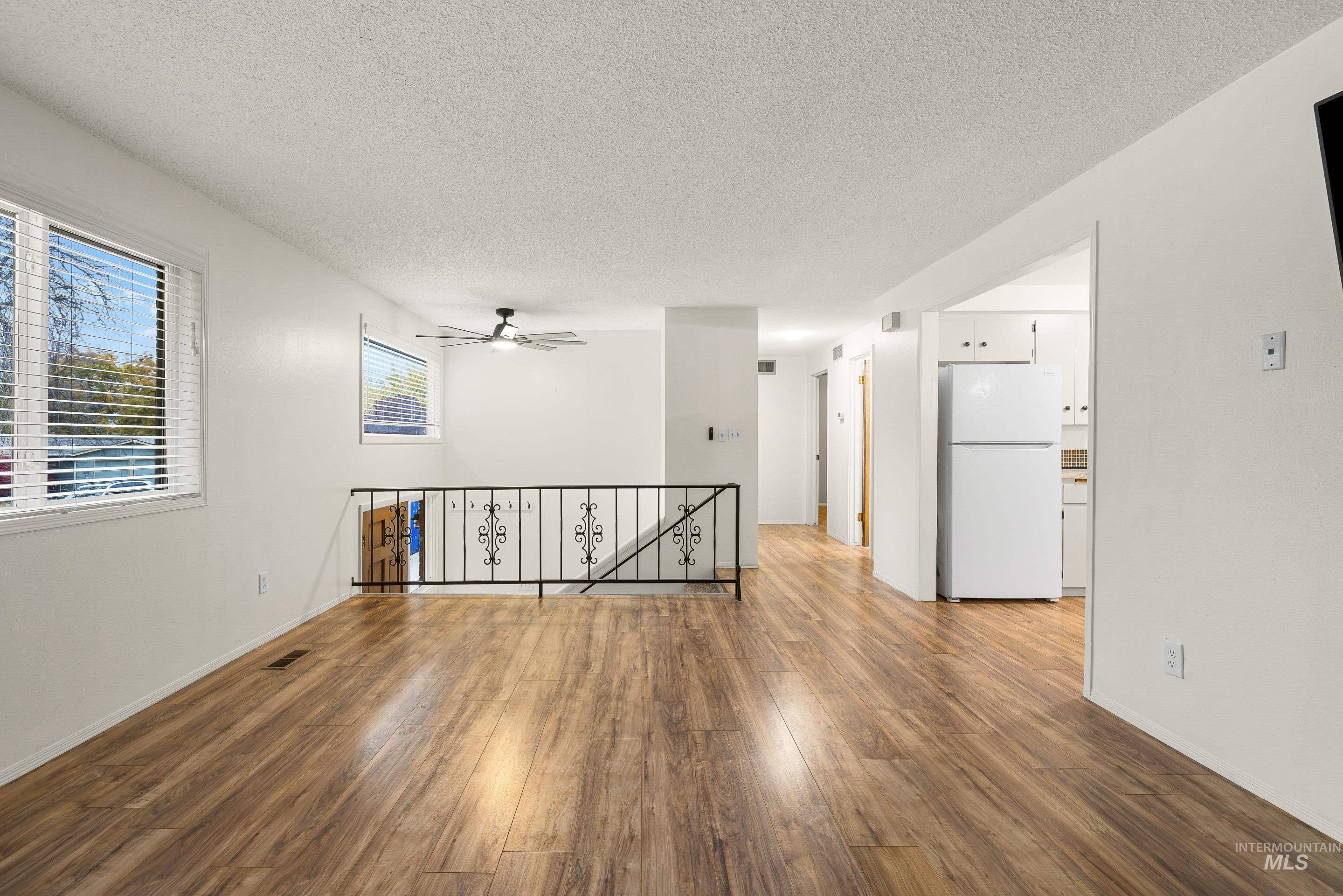 Spare room featuring a textured ceiling, wood finished floors, and ceiling fan