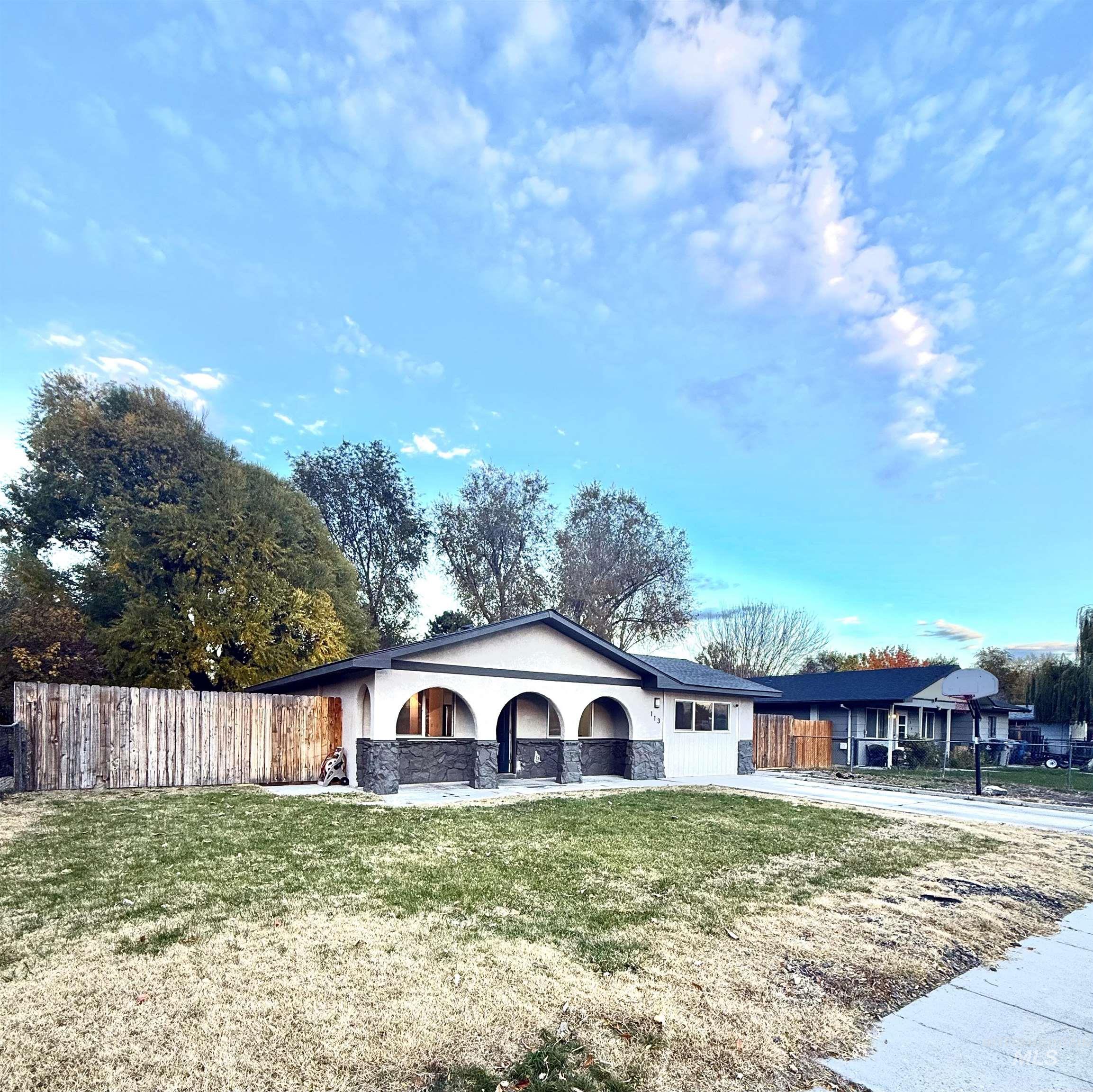 View of front of home with stucco siding, stone siding, and a porch