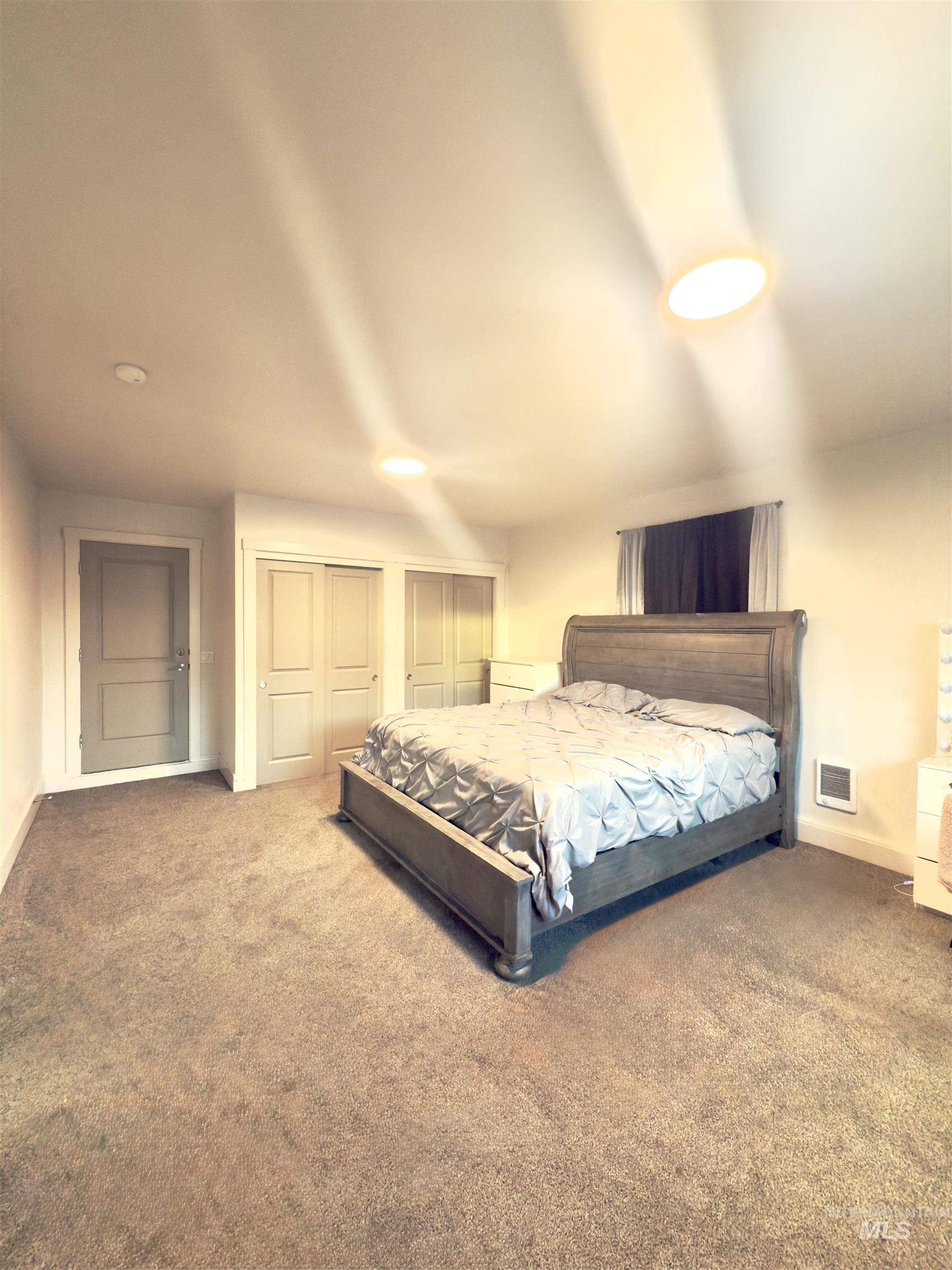 Bedroom featuring two closets and carpet floors