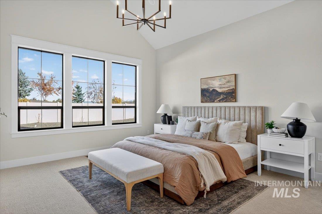 Bedroom featuring light colored carpet, a chandelier, and high vaulted ceiling