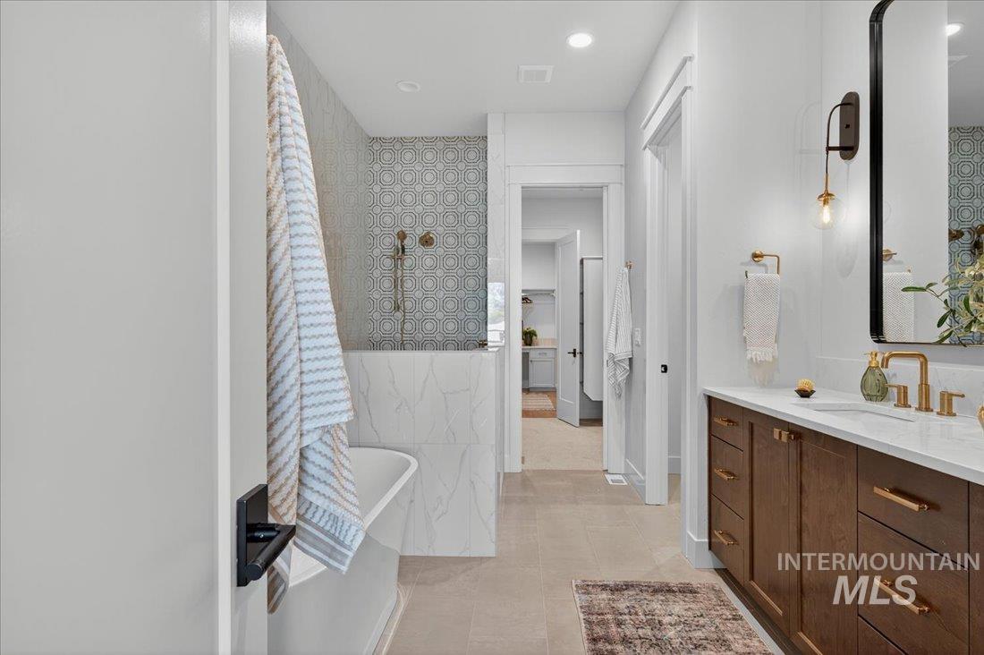 Bathroom with vanity, a soaking tub, recessed lighting, wallpapered walls, and light tile patterned flooring