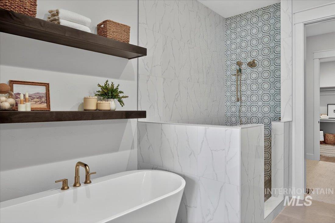 Full bath with tile walls and a freestanding bath
