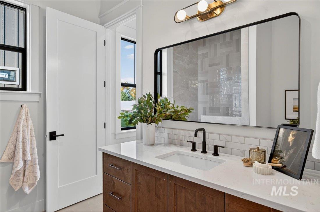 Bathroom with tasteful backsplash, vanity, and a tile shower