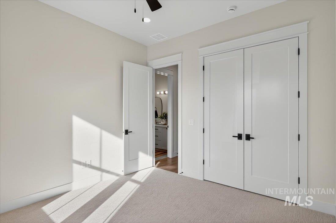 Unfurnished bedroom featuring carpet, a closet, and ceiling fan