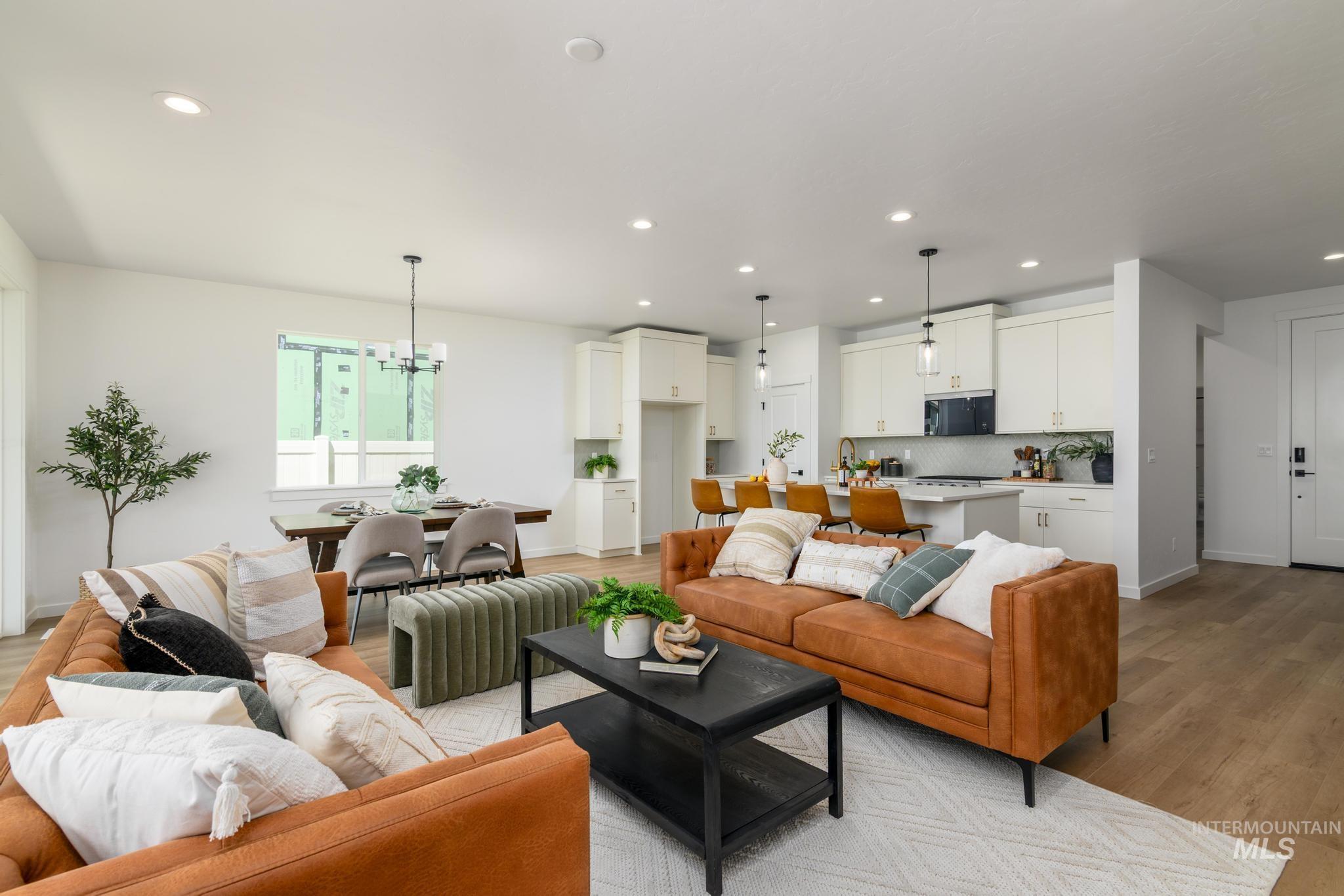 Living area with light wood-style floors, recessed lighting, and a chandelier