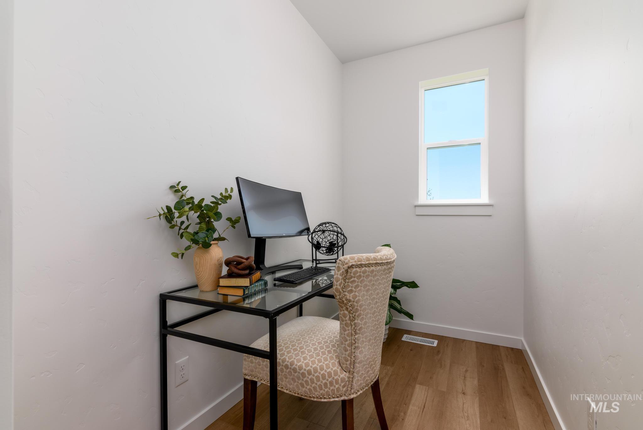 Home office with light wood-type flooring and baseboards