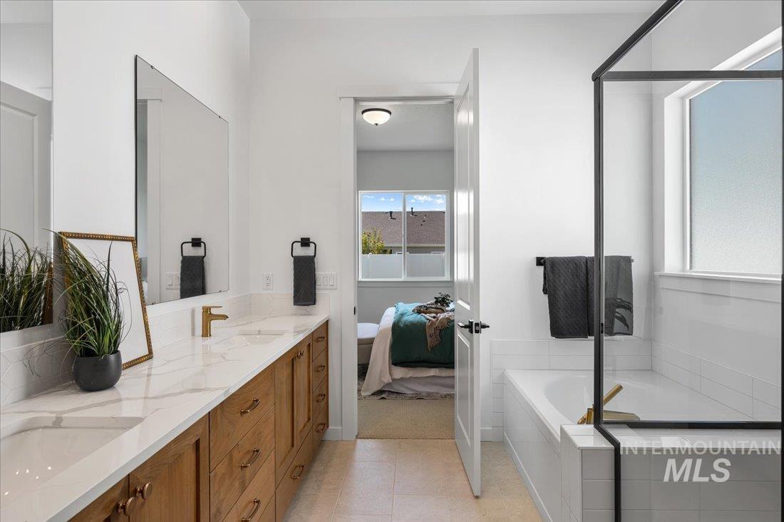 Bathroom with double vanity, a bath, and ensuite bathroom