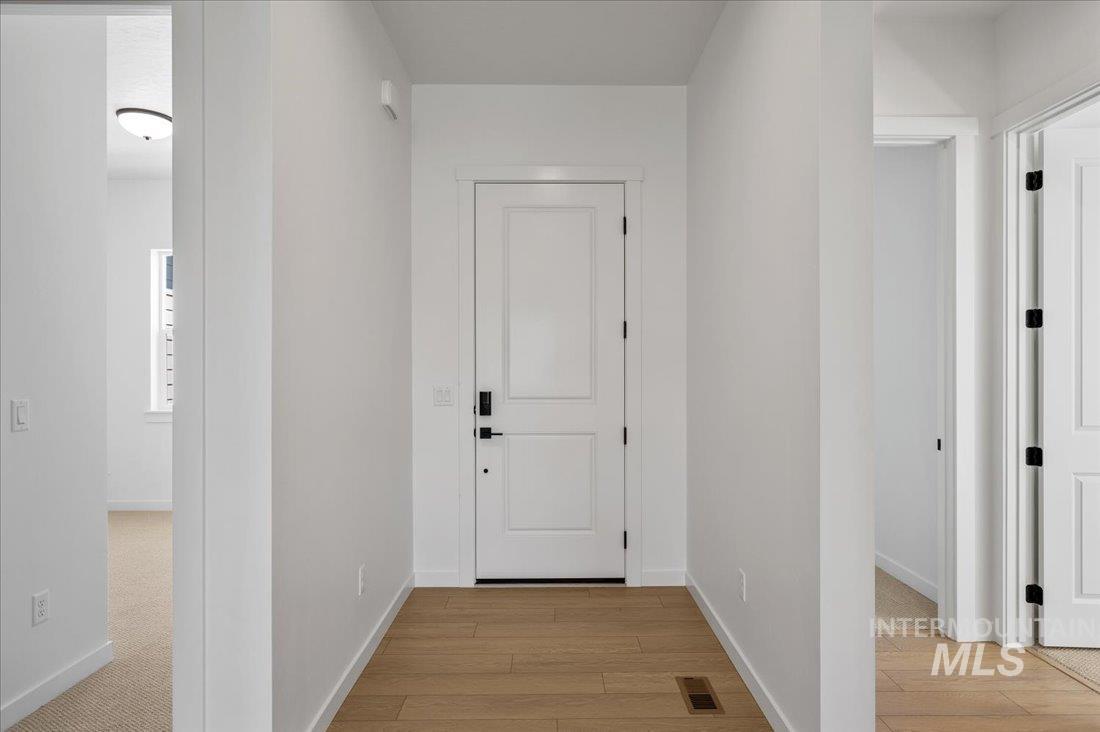 Hall with baseboards and light wood-style floors