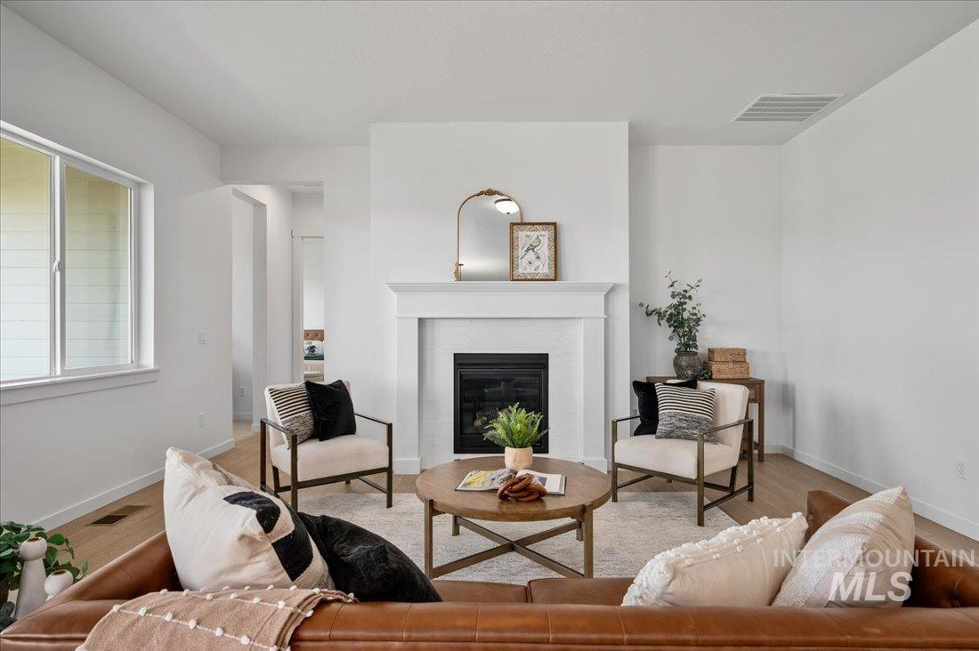 Living room featuring light wood-style flooring and a glass covered fireplace