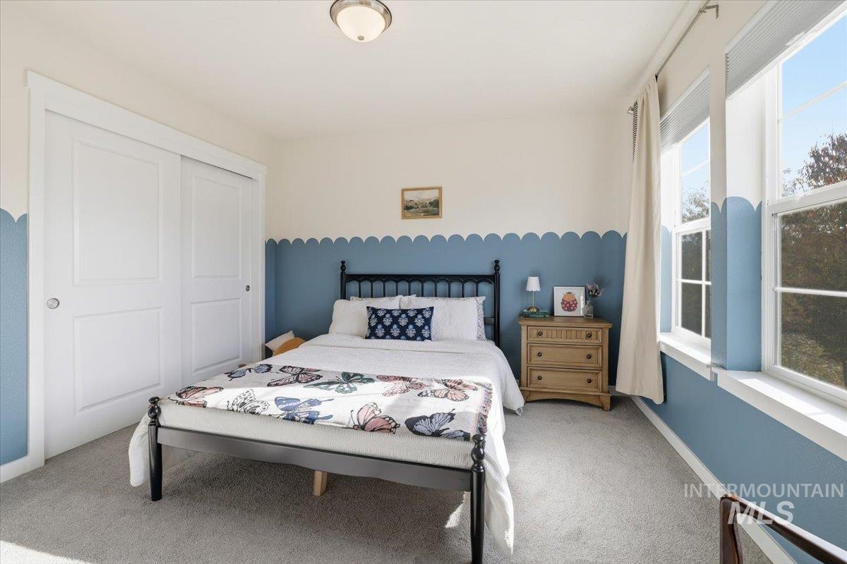 Bedroom with light colored carpet and a closet