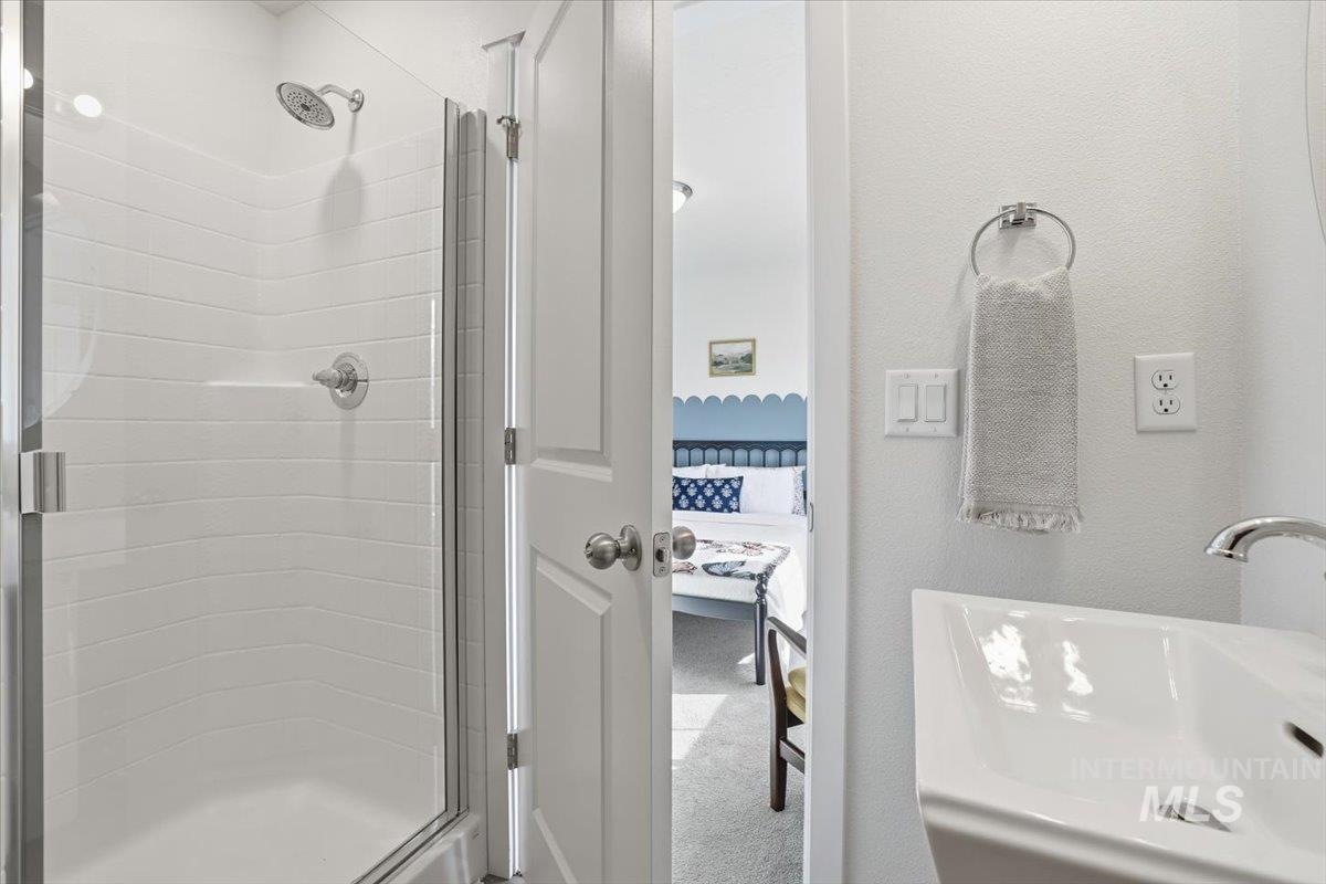 Bathroom featuring ensuite bath, a shower stall, a textured wall, and carpet floors
