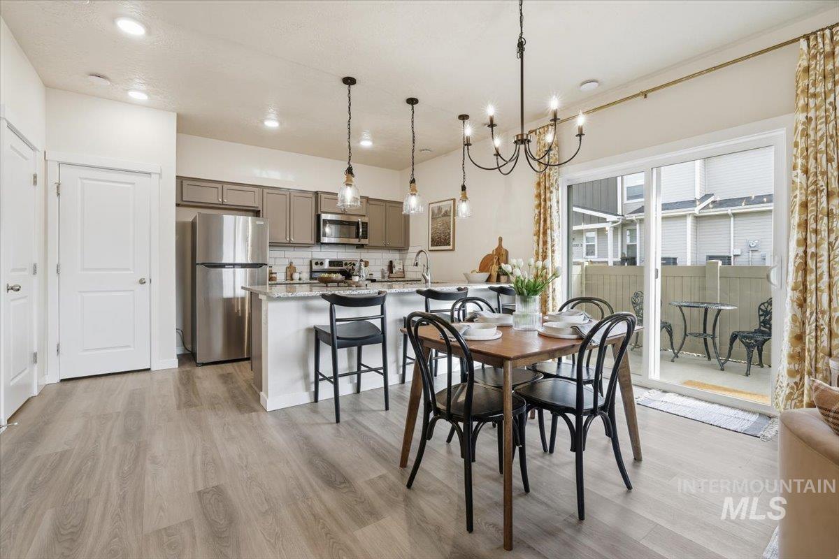 Dining room with a chandelier, light wood finished floors, and recessed lighting