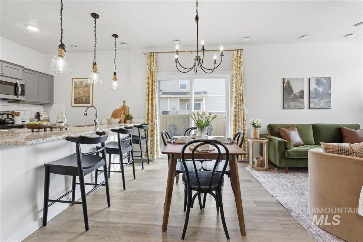 Dining space with light wood-style floors and a chandelier