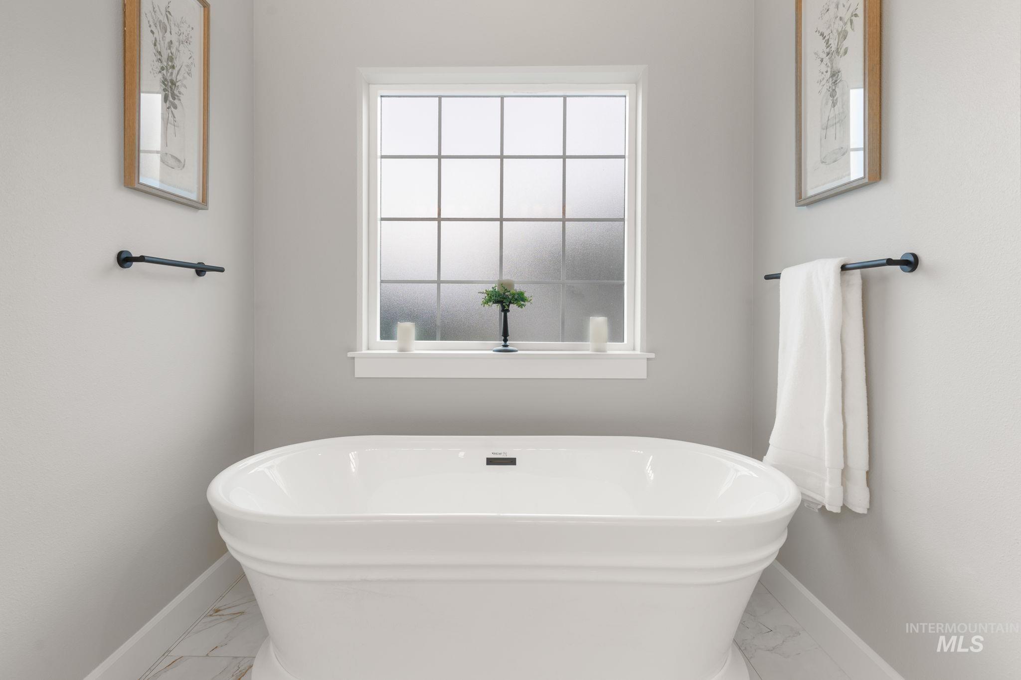 Full bathroom featurin tiled flooring and a freestanding tub