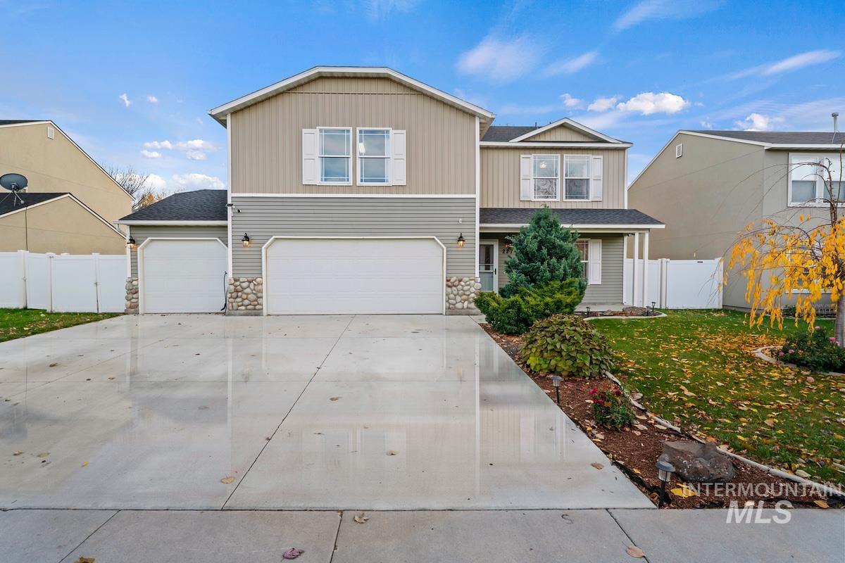 View of front of home featuring stone siding, concrete driveway, an attached garage, and a shingled roof