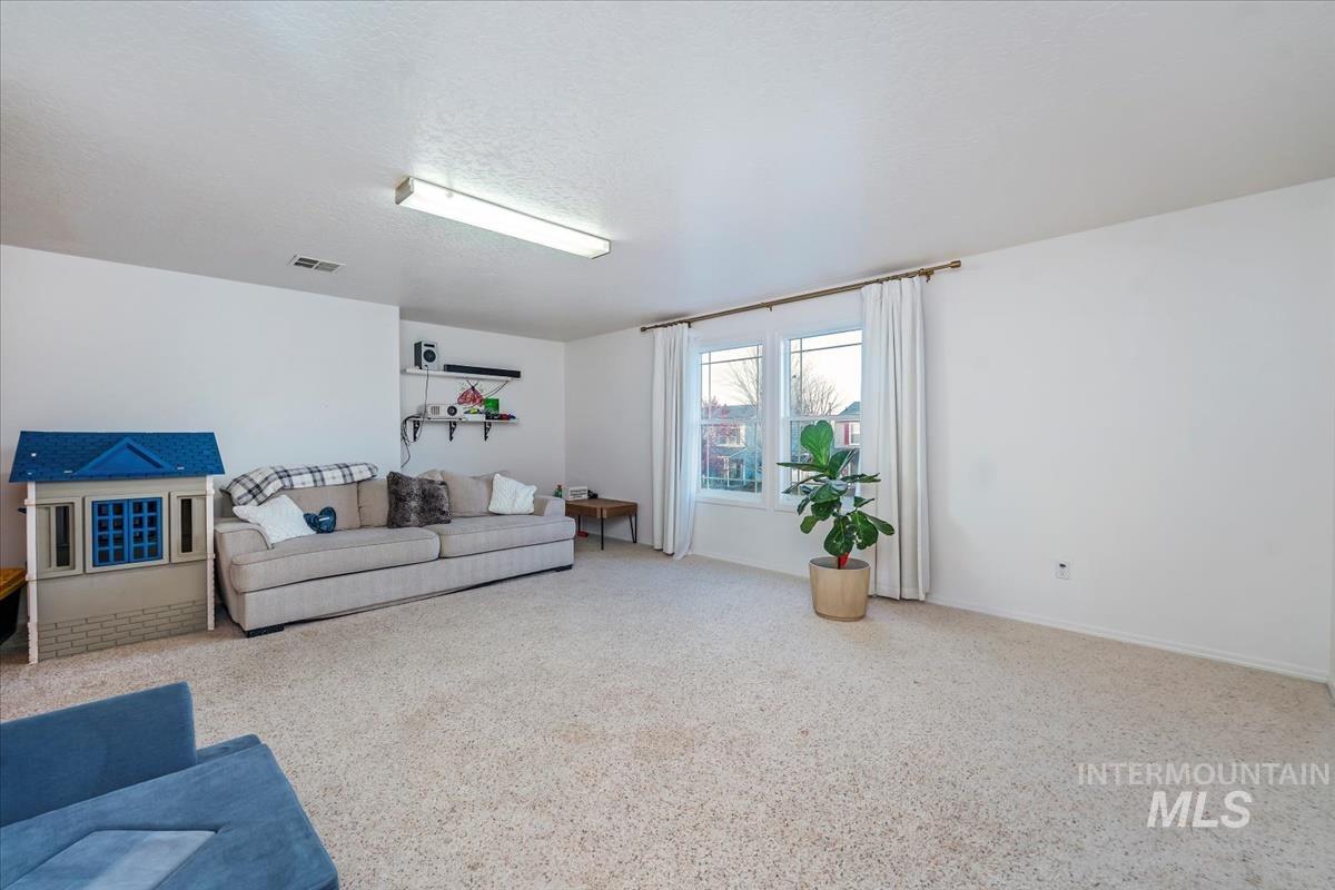 Carpeted living room with baseboards and a textured ceiling