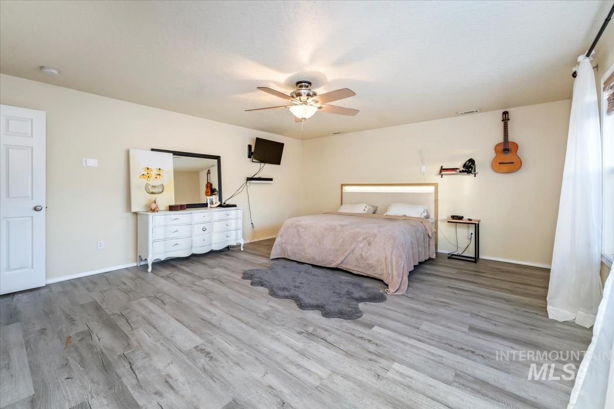 Bedroom with light wood-style flooring and a ceiling fan