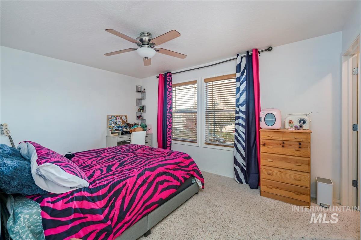 Carpeted bedroom featuring ceiling fan